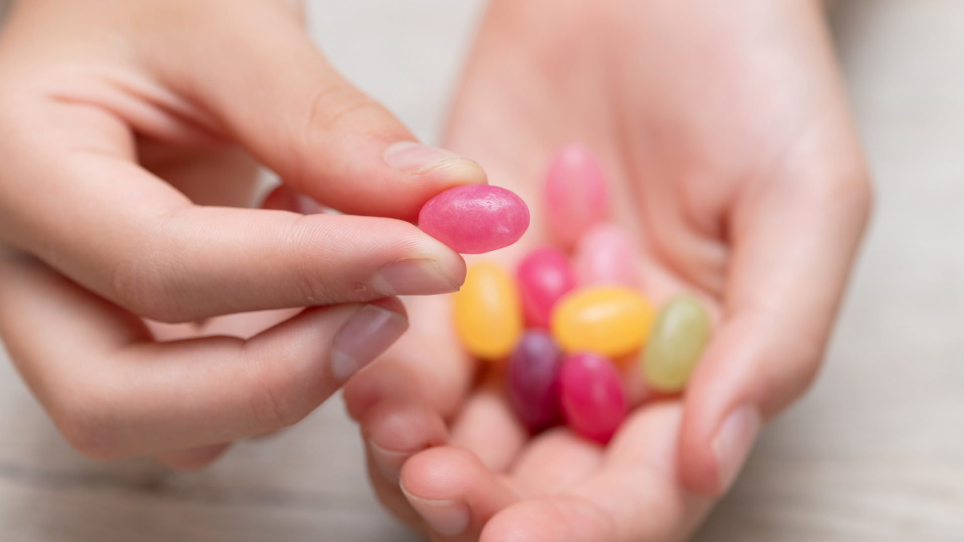 Hand hält bunte Geleebohnen.