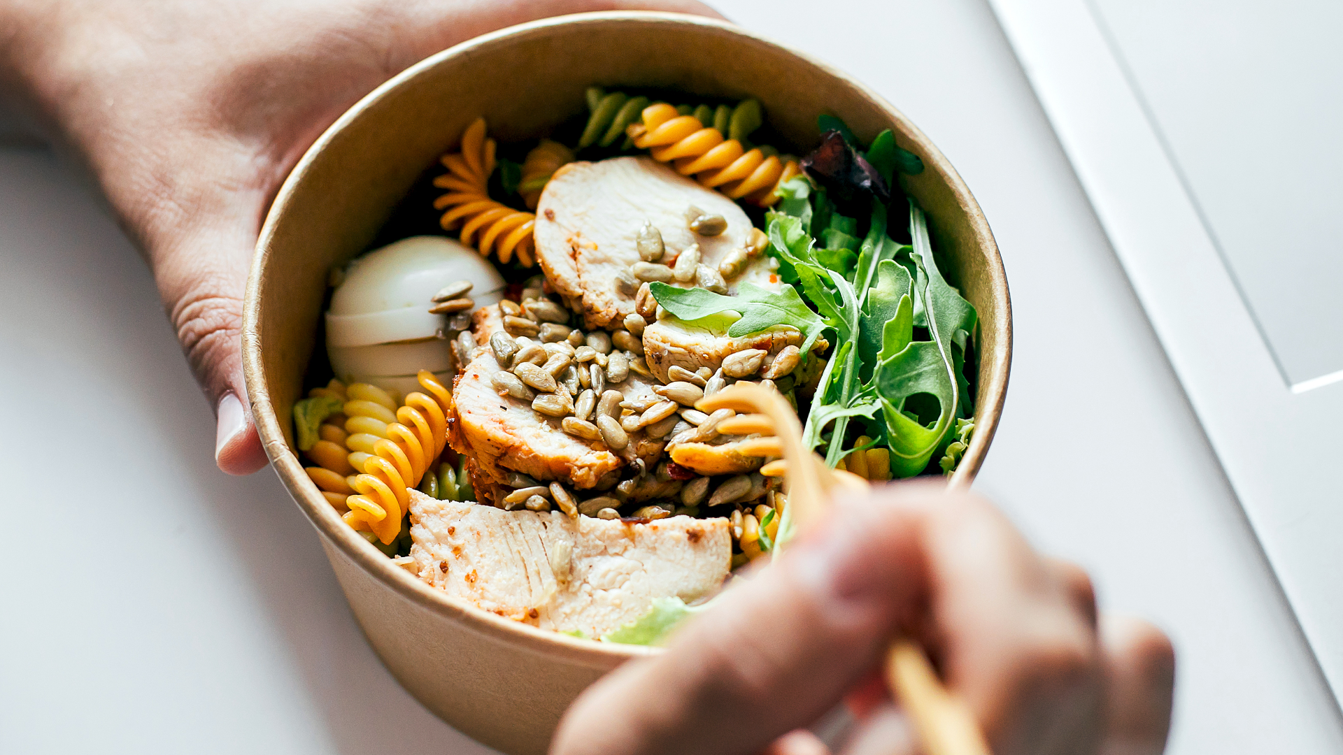 Salat mit Hühnchen, Nudeln, Ei und Sonnenblumenkernen.