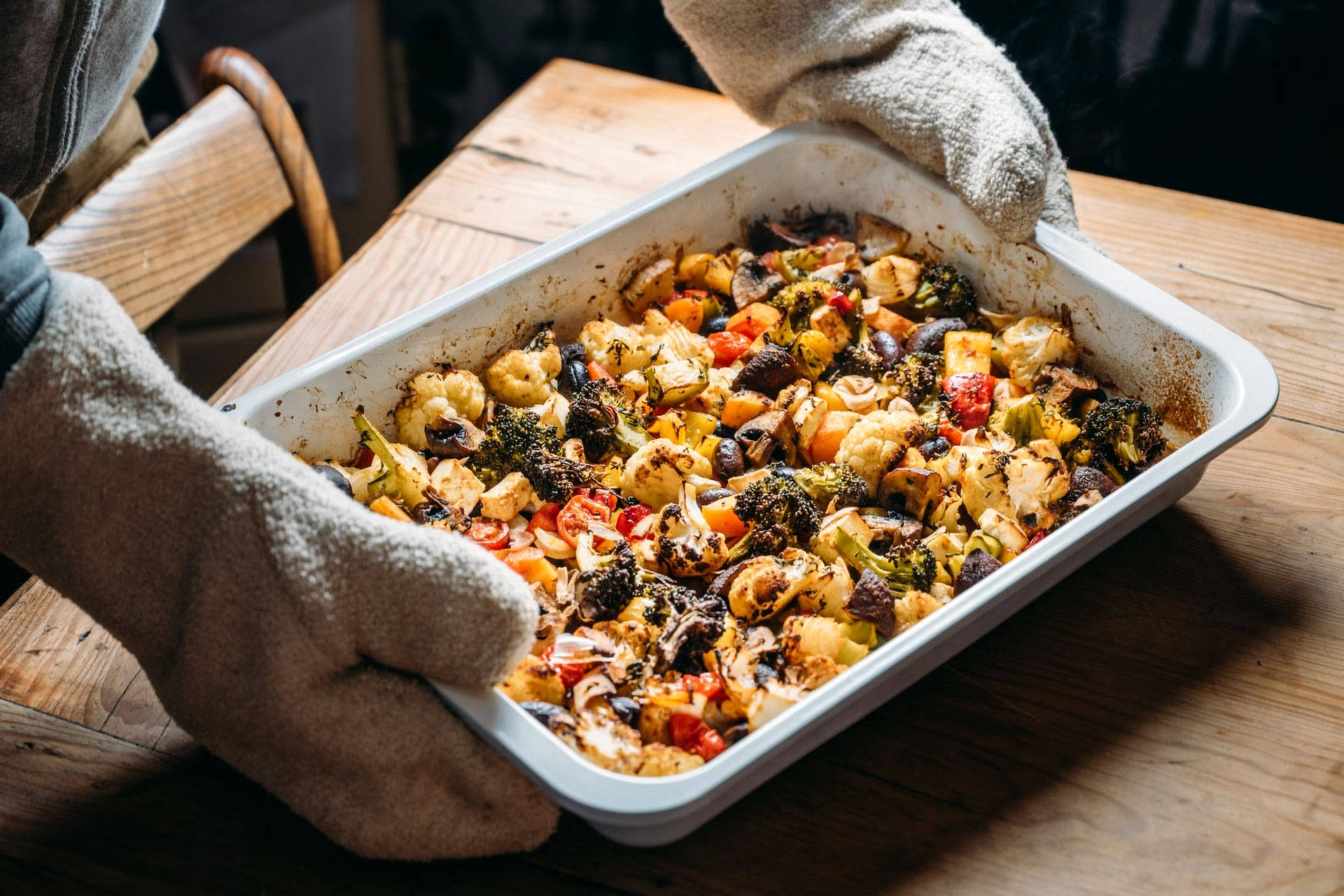 Ein ofenfrischer Auflauf aus Wintergemüse wird gerade auf dem Tisch serviert.