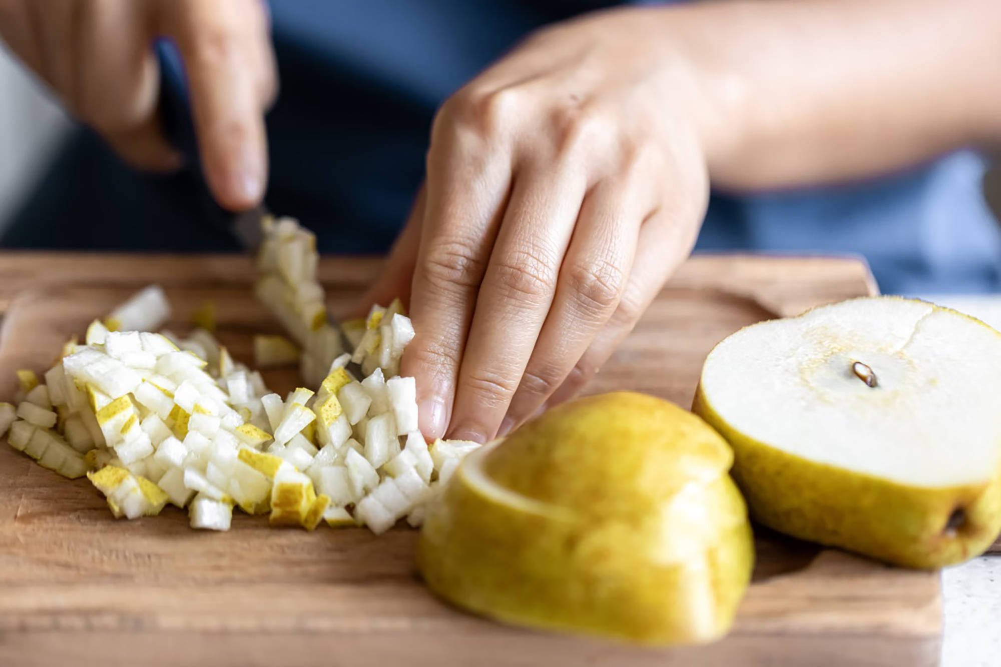 Klein gewürfelte Birnenstücke werden vorbereitet, um für das Einkochen im Backofen verwendet zu werden.