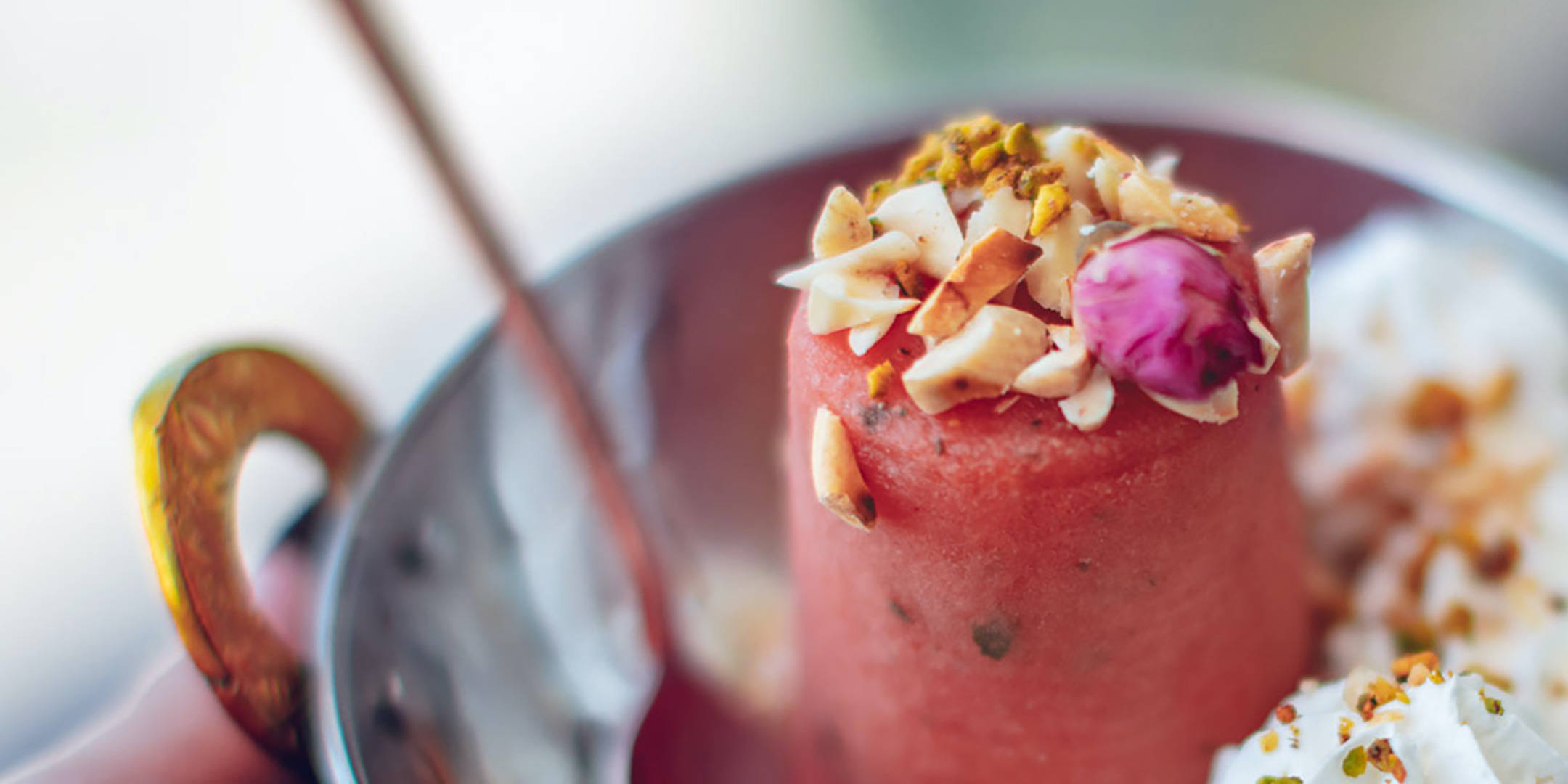 Wassermelonen-Eis mit Nüssen und Rosenknospe.