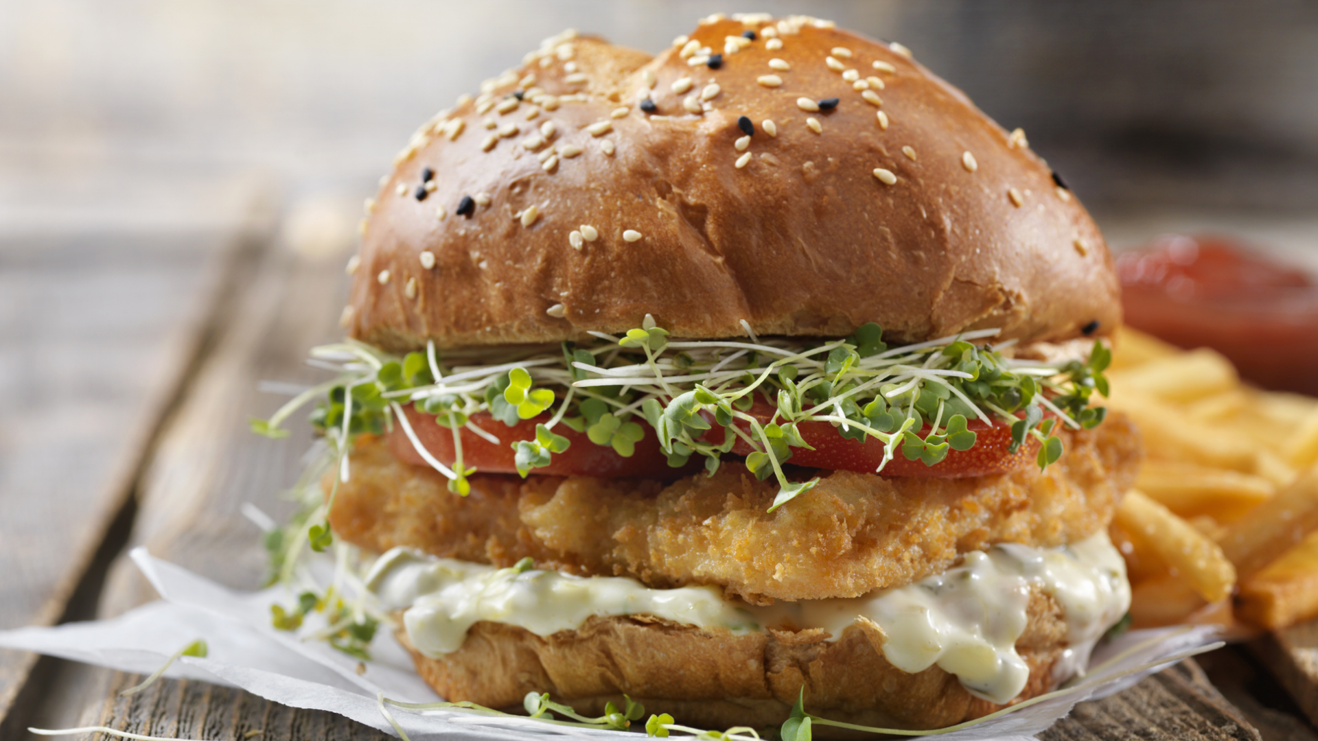 Burger mit knusprigen Patties, Tomate, Sprossen und Sauce.