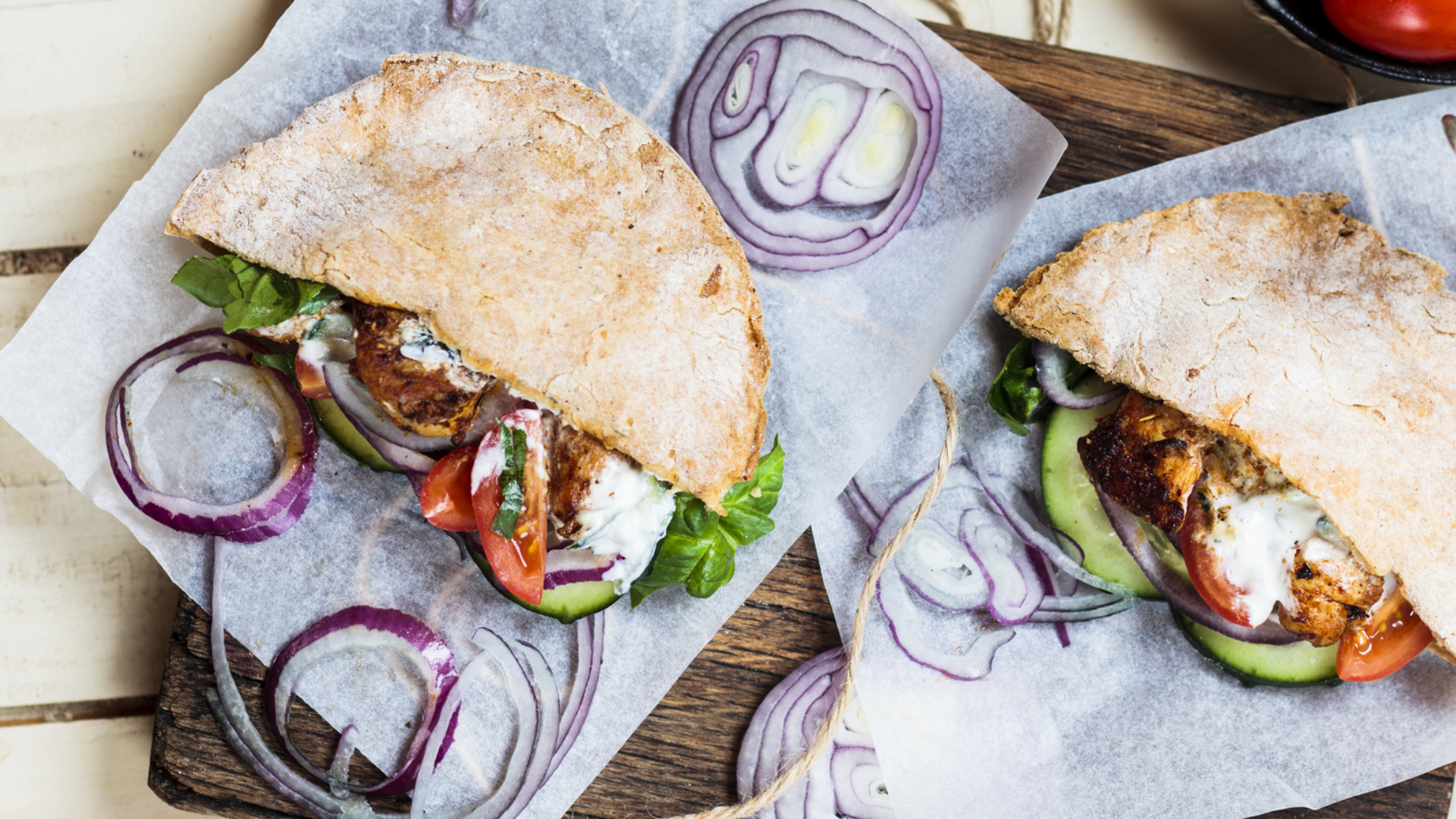 Zwei Fladenbrot-Sandwiches mit Fleischersatz, Gemüse und Zwiebeln.