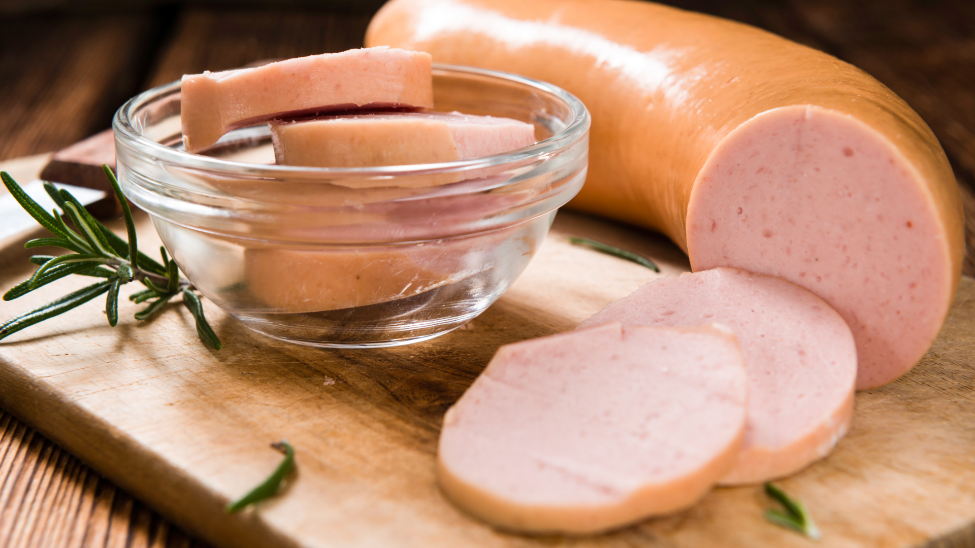 Ganze und geschnittene Fleischwurst mit Rosmarin.