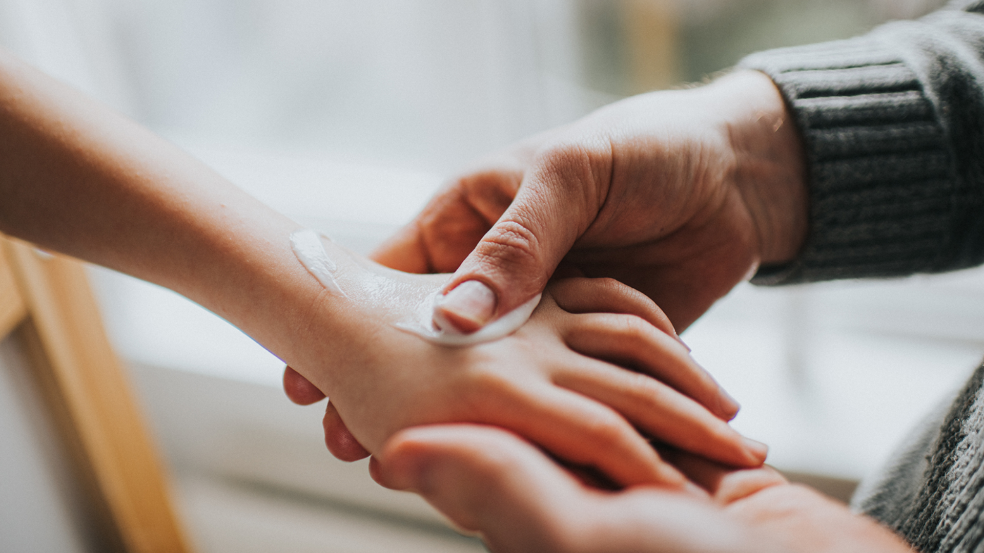 Creme wird auf Kinderhand aufgetragen.