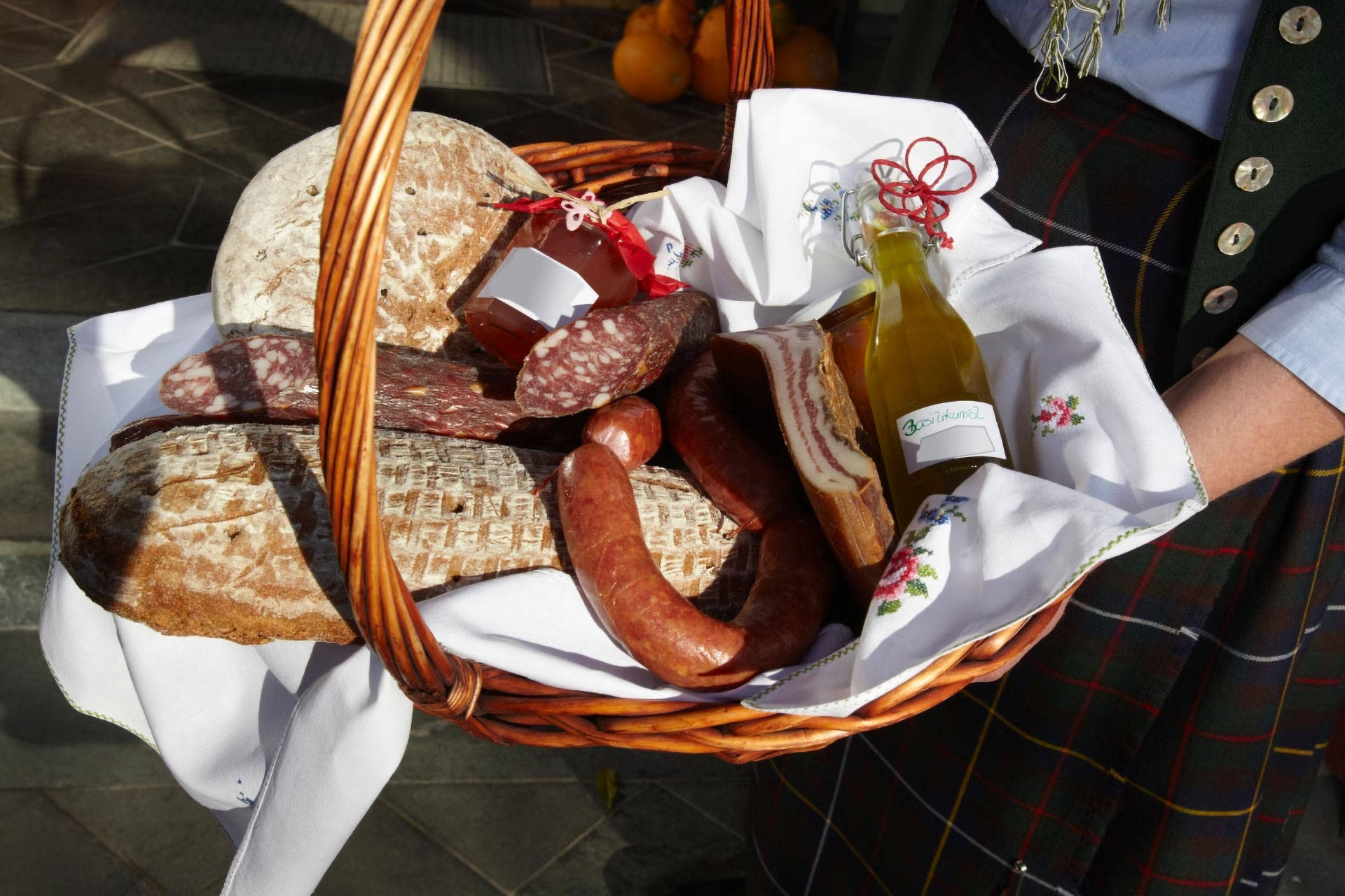 Ein Feinkost-Geschenkkorb mit regionalen Spezialitäten wie Brot und Wurst.