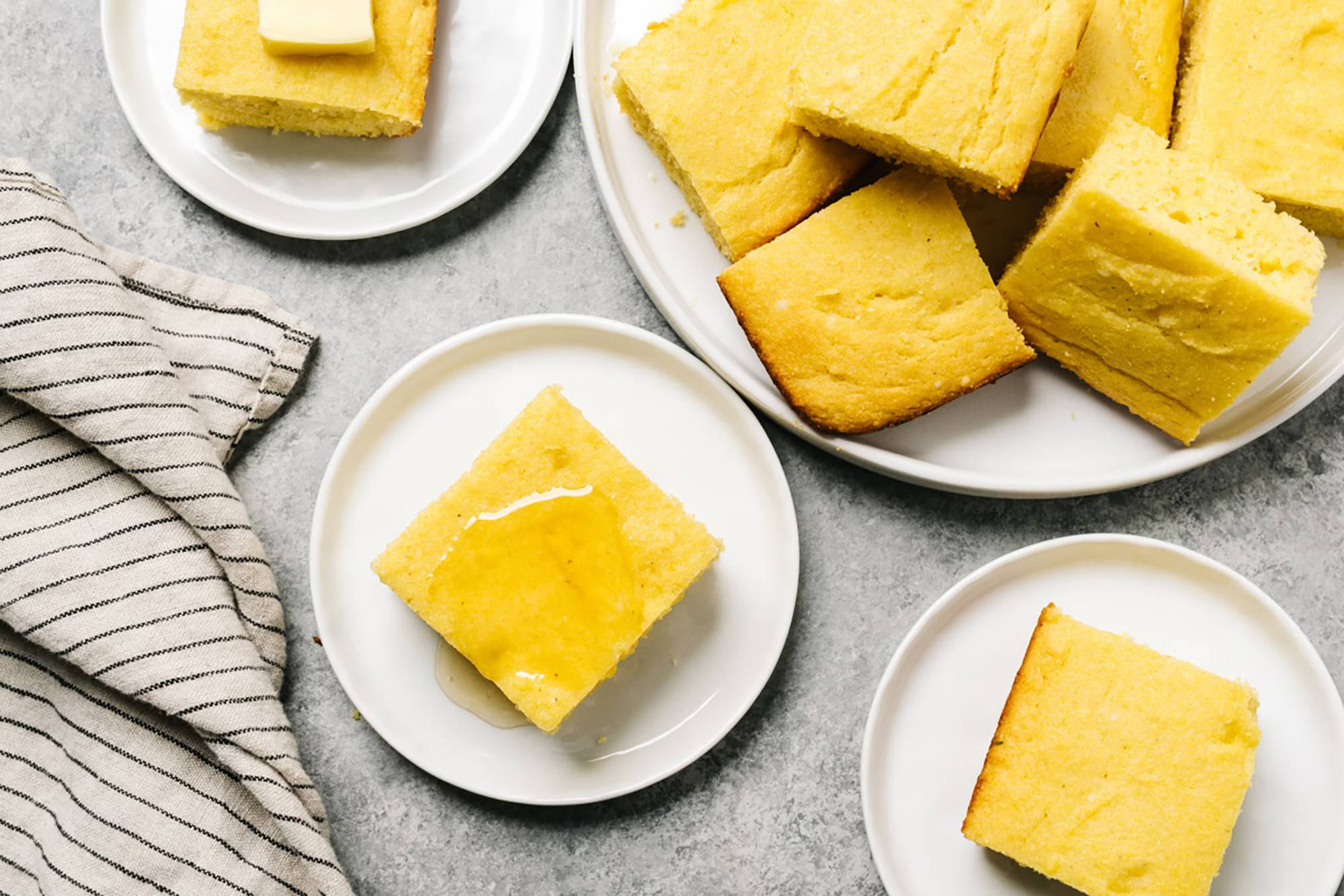 Goldfarbene Polentastücke aus glutenfreiem Maismehl auf Tellern.