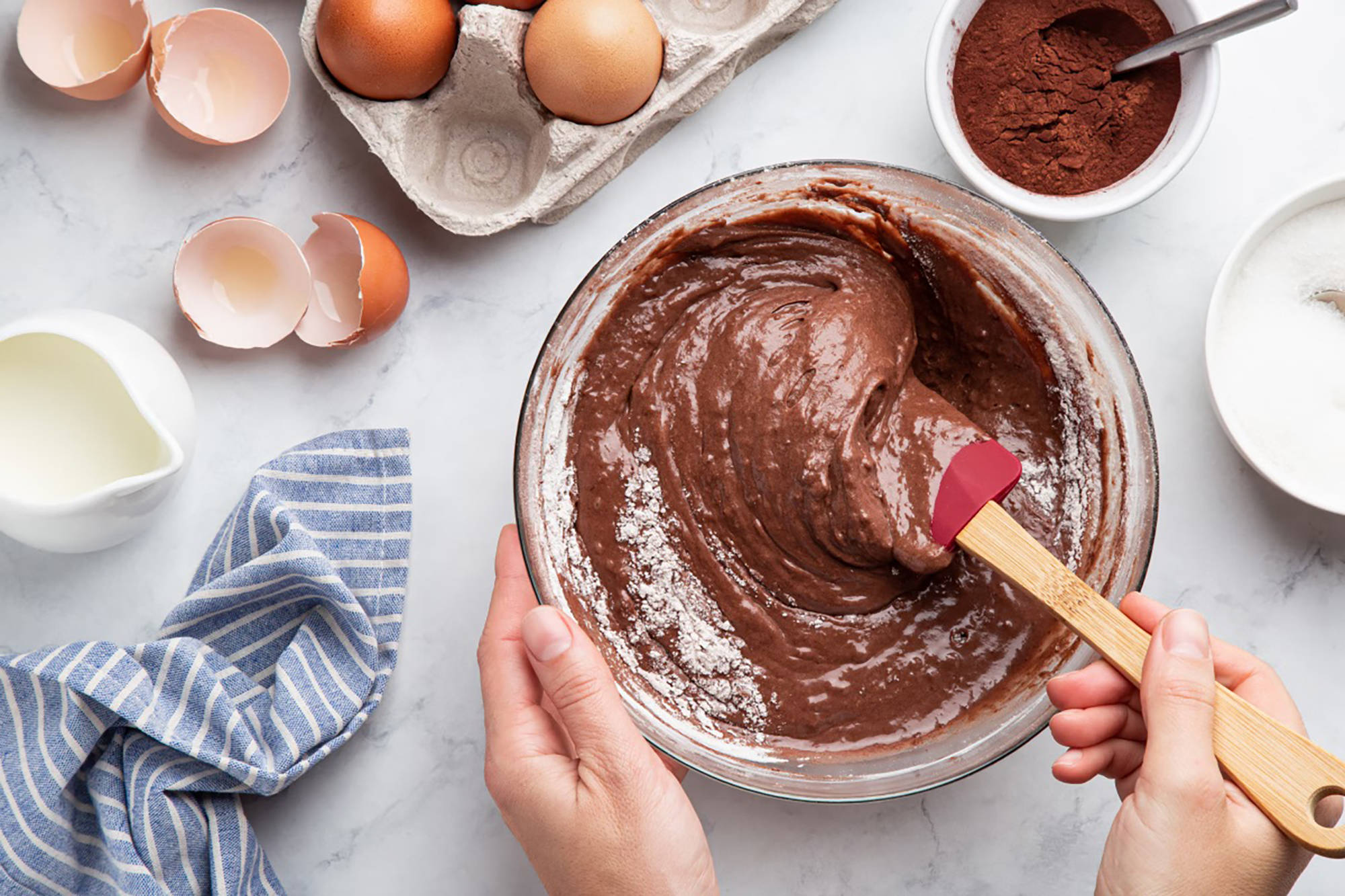 Eine Person rührt einen glutenfreien Schokoladenteig in einer Schüssel an.