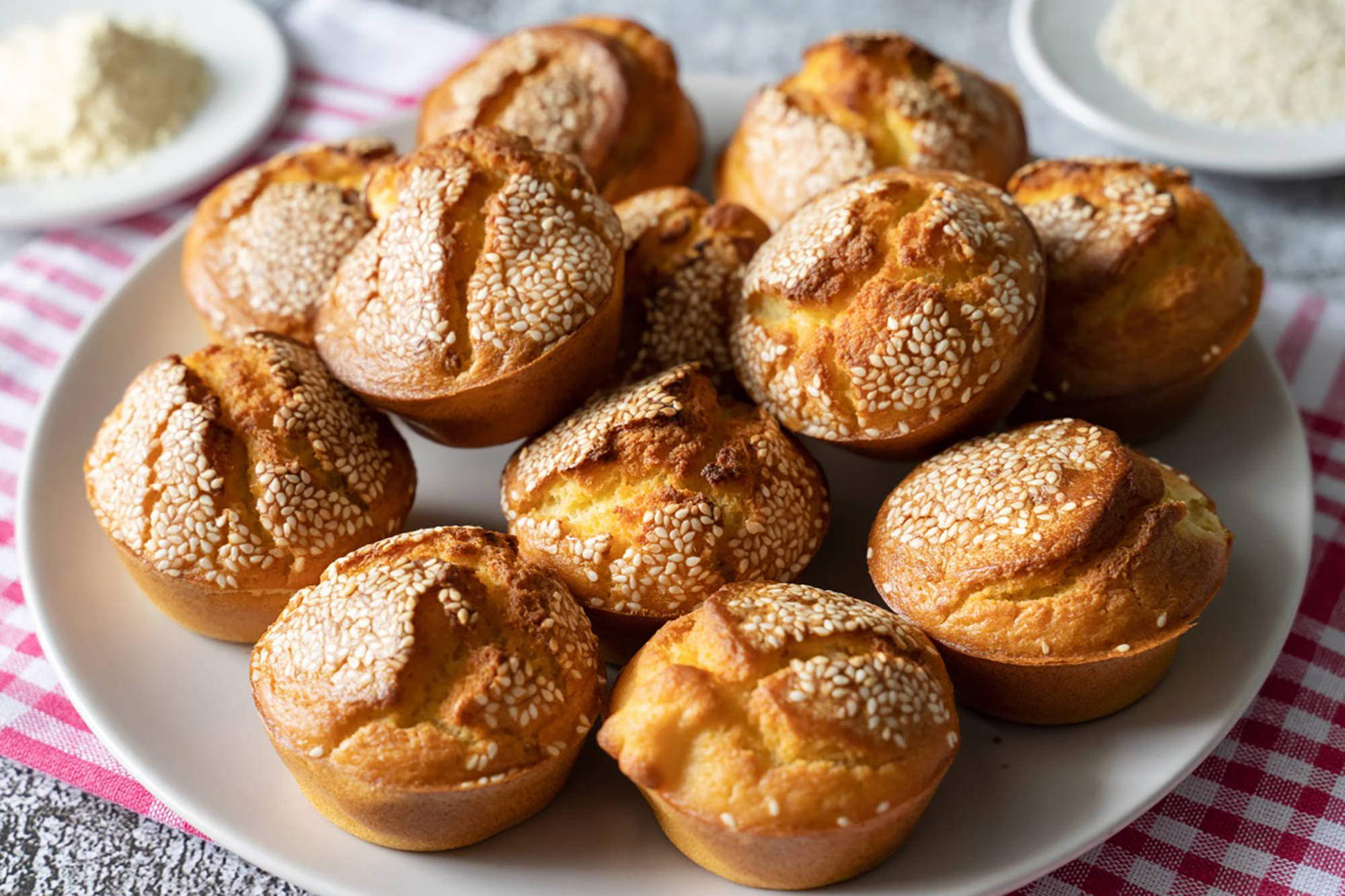 Herzhafte und glutenfreie Muffins mit Sesam-Topping auf einem Teller.