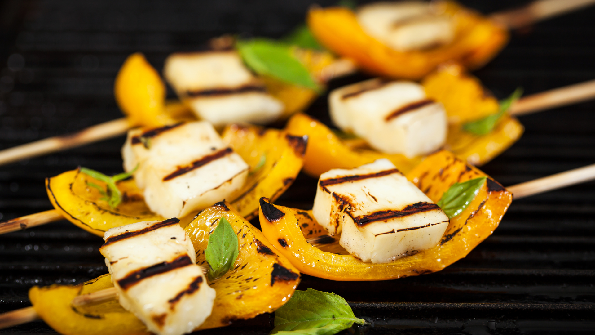 Gegrillter Käse und Paprika auf Spießen auf dem Grill.