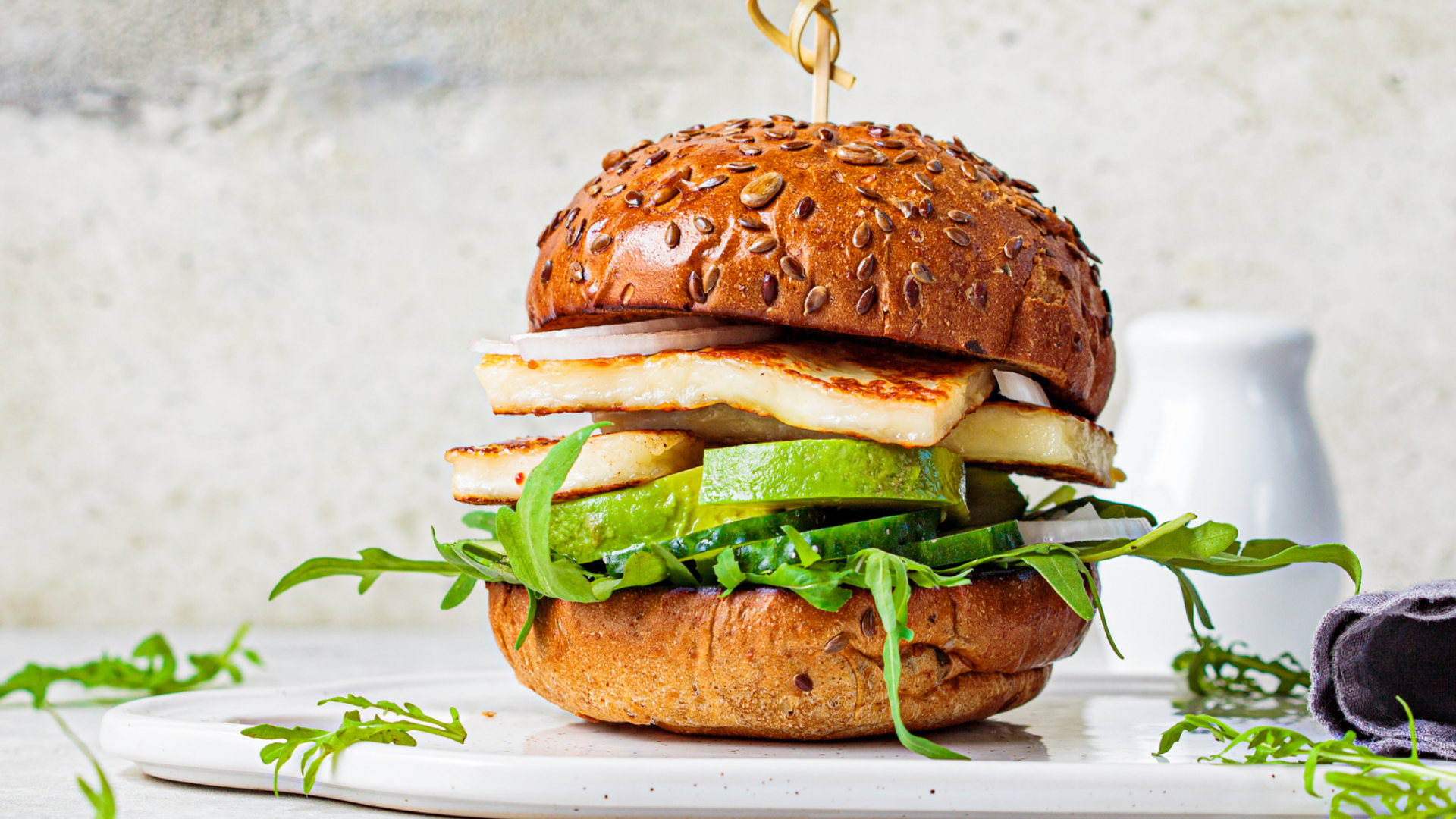 Grillkäse-Burger mit Rucola, Gurke und Zwiebeln