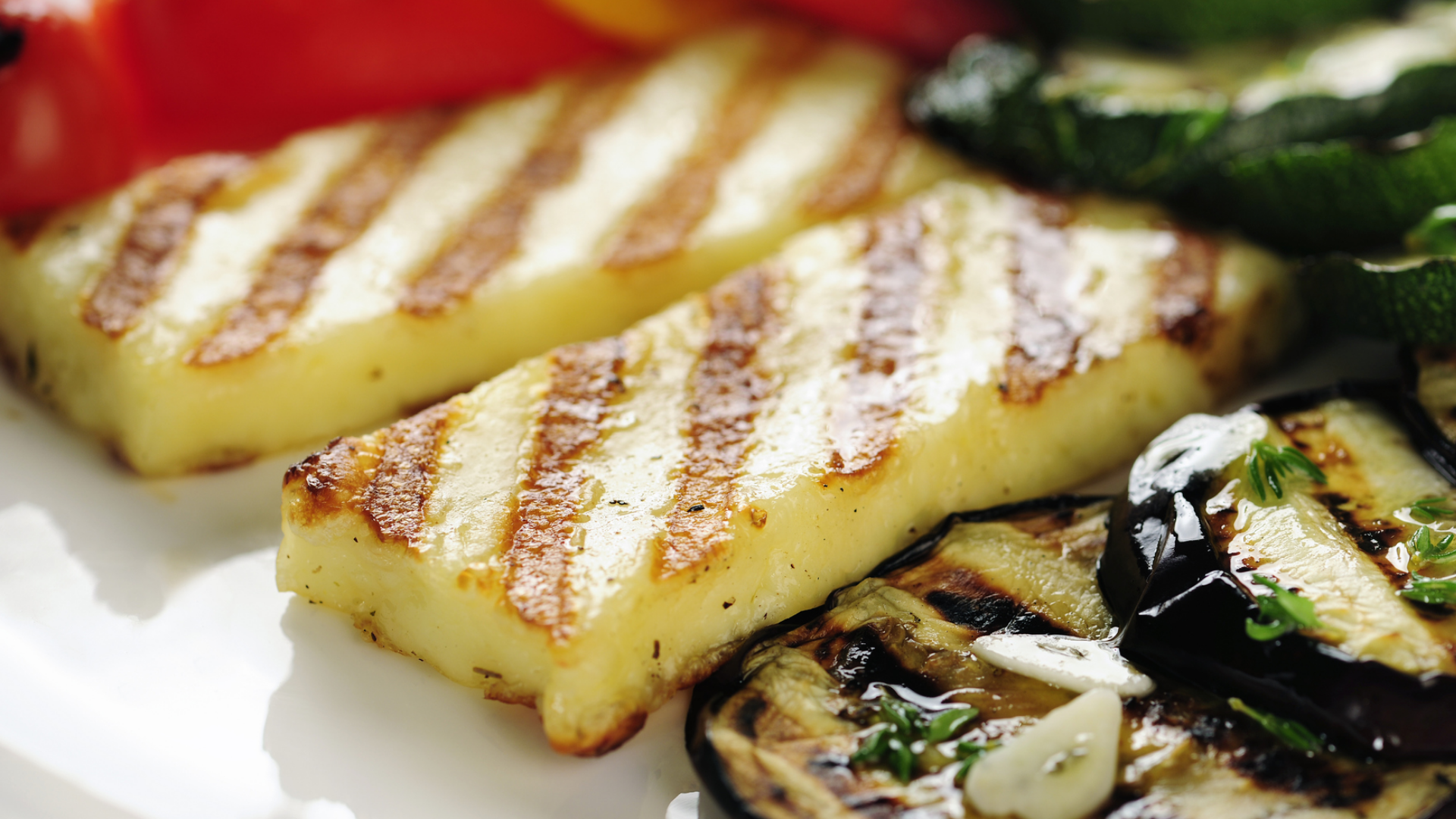 Gegrillter Käse mit Gemüse auf einem Teller.