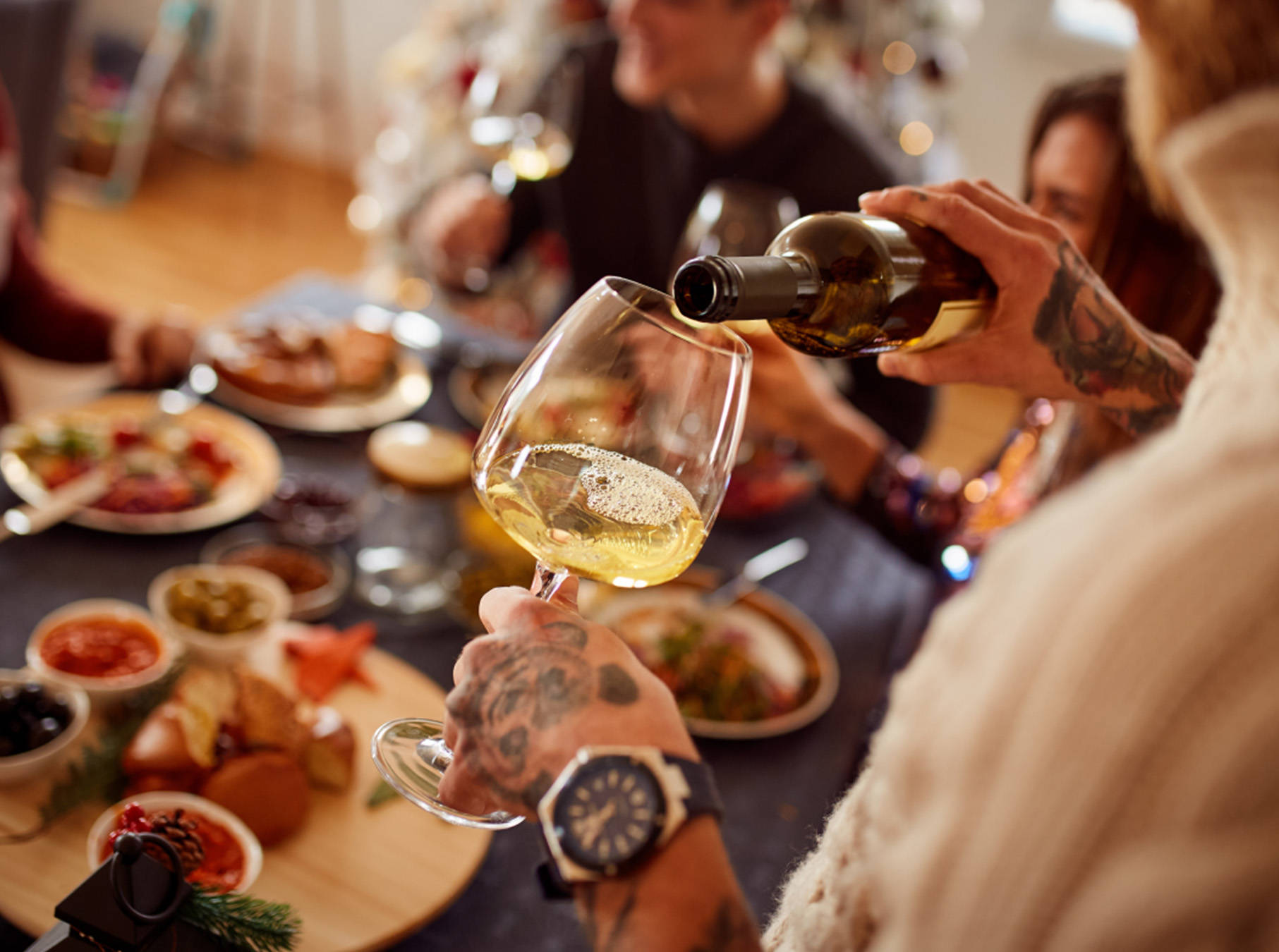 Eine Person schenkt sich ein Glas Wein zum Abendessen ein.