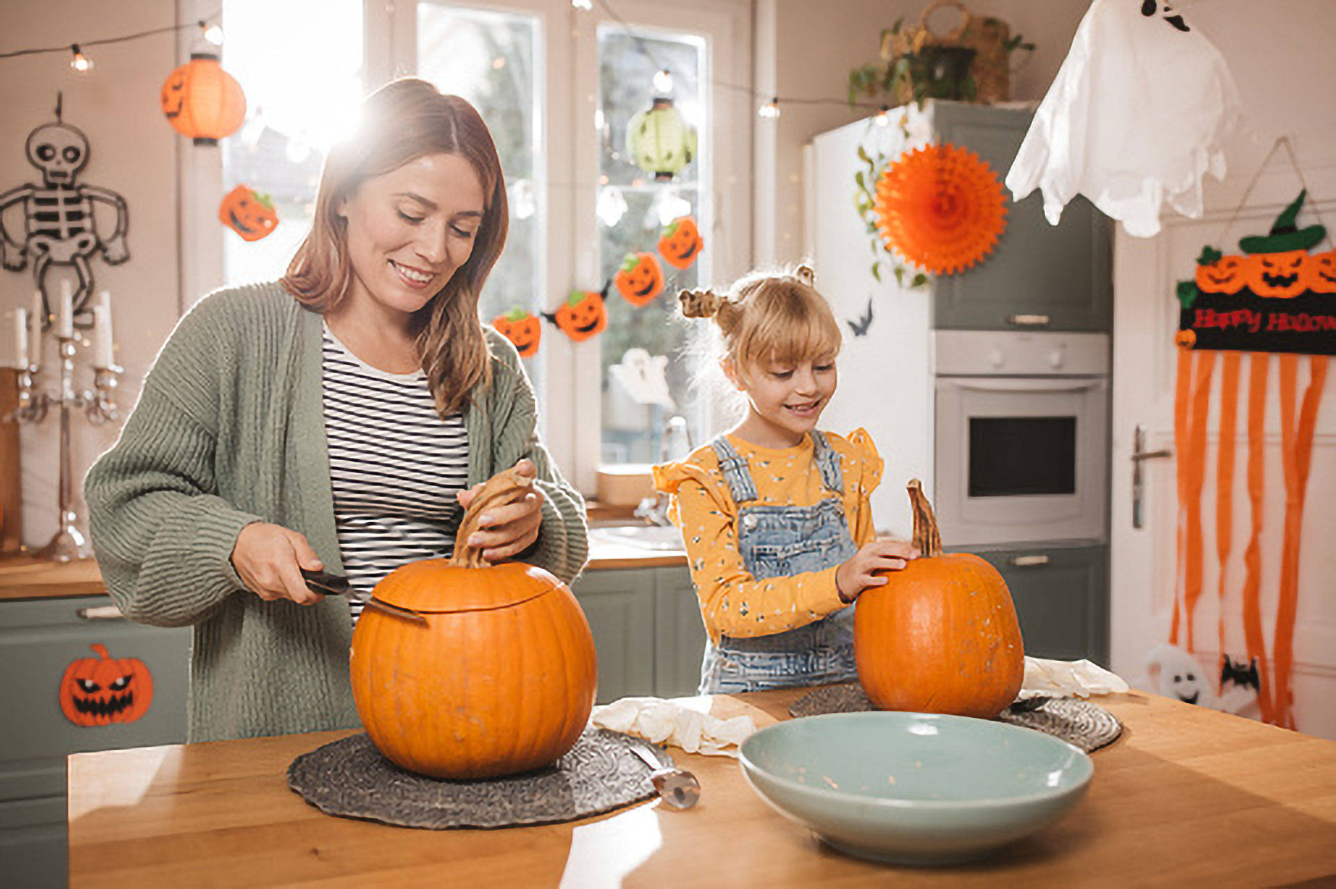 Eine Frau und ein Kind schnitzen Kürbisse.