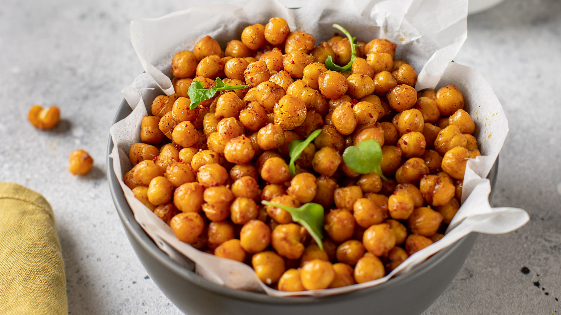 Geröstete gewürzte Kichererbsen in einer Schale mit Grün.