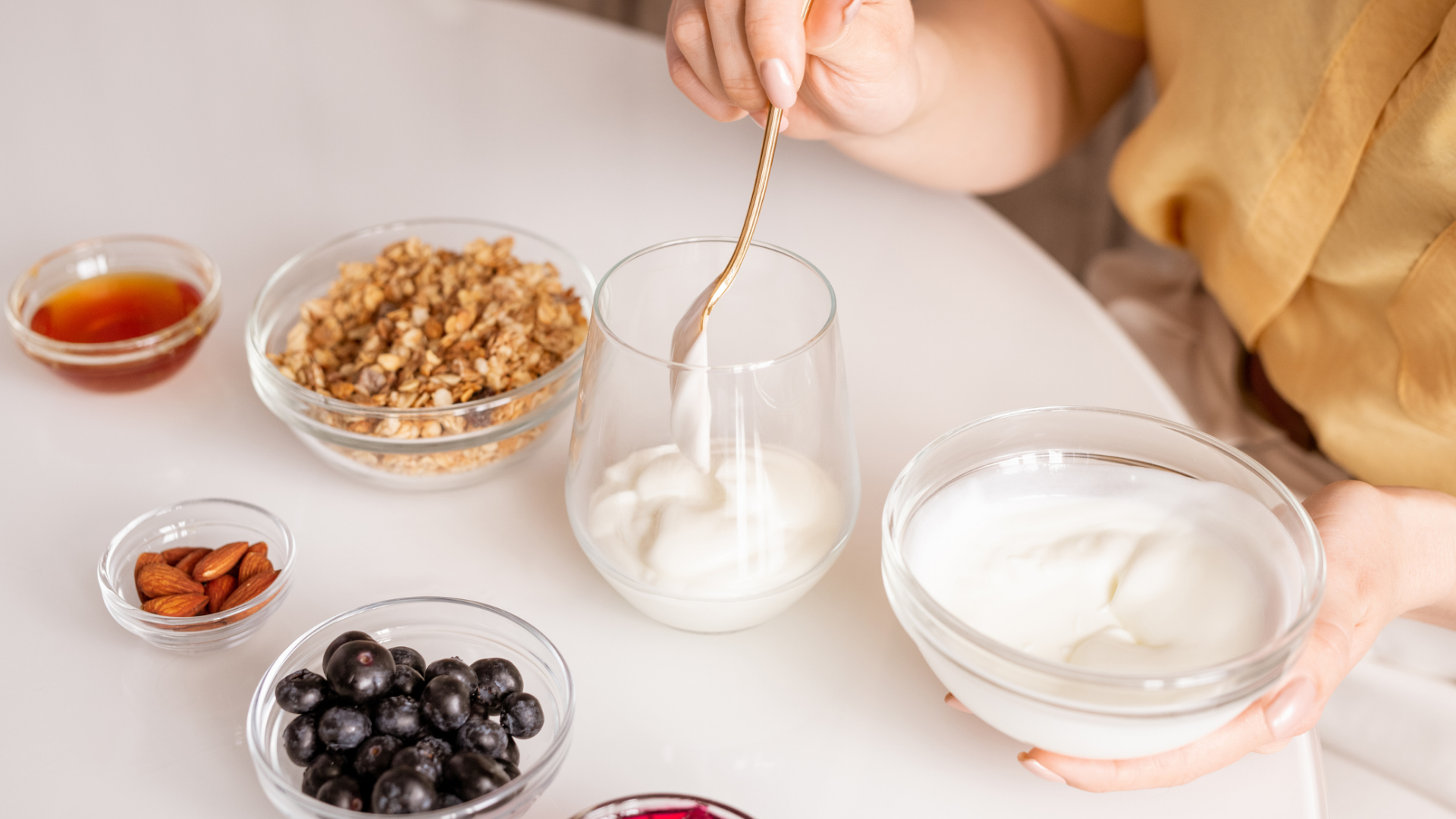Joghurt mit Müsli, Beeren, Mandeln und Honig zubereiten.