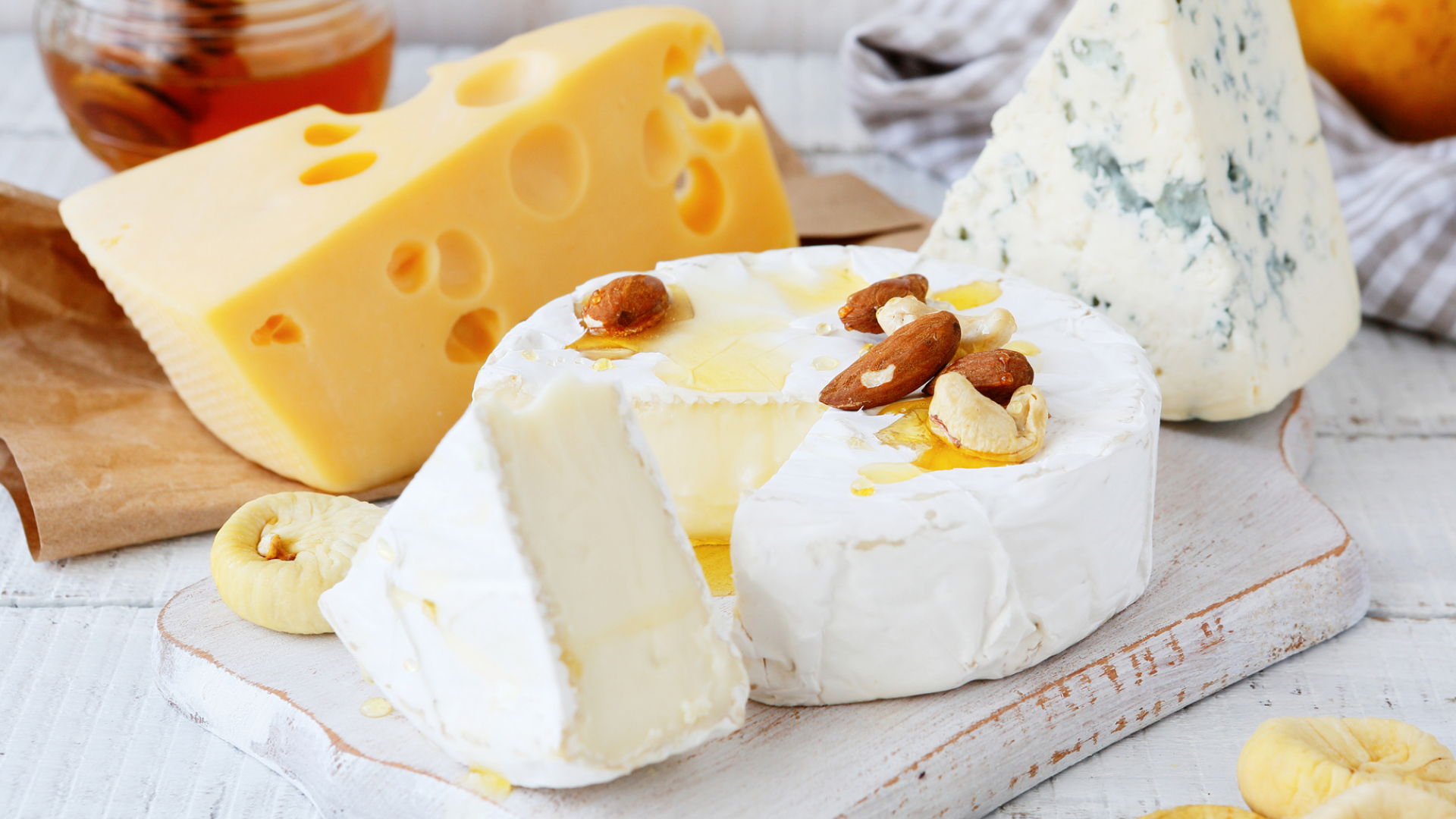 Käseauswahl: Emmentaler, Blauschimmelkäse, Brie mit Nüssen.