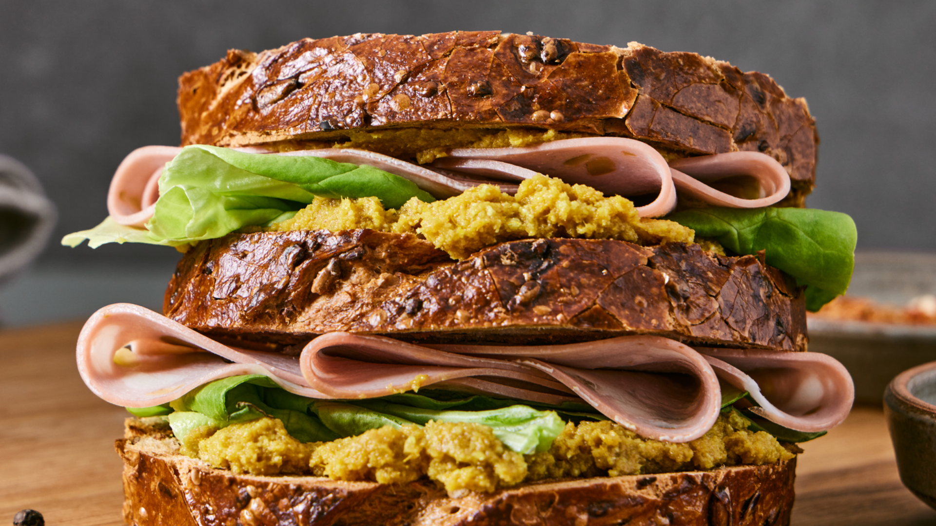 Karottenstück wird in veganen Aufstrich getaucht.