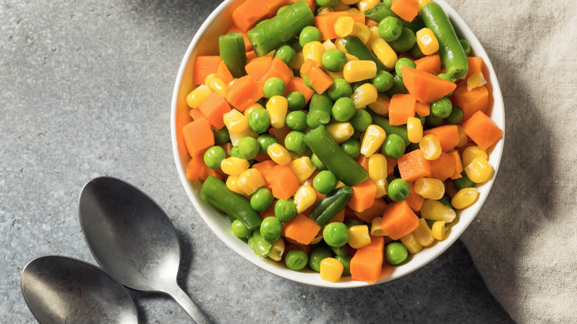 Schüssel mit Mischgemüse: Karotten, Erbsen, Mais, Bohnen.