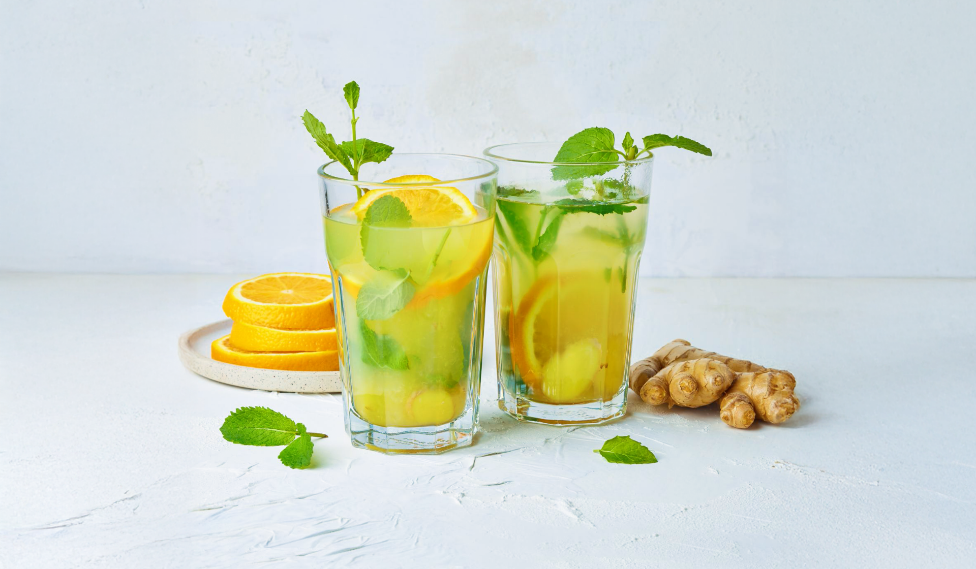 Zwei Gläser mit Orangen-Ingwer-Minztee