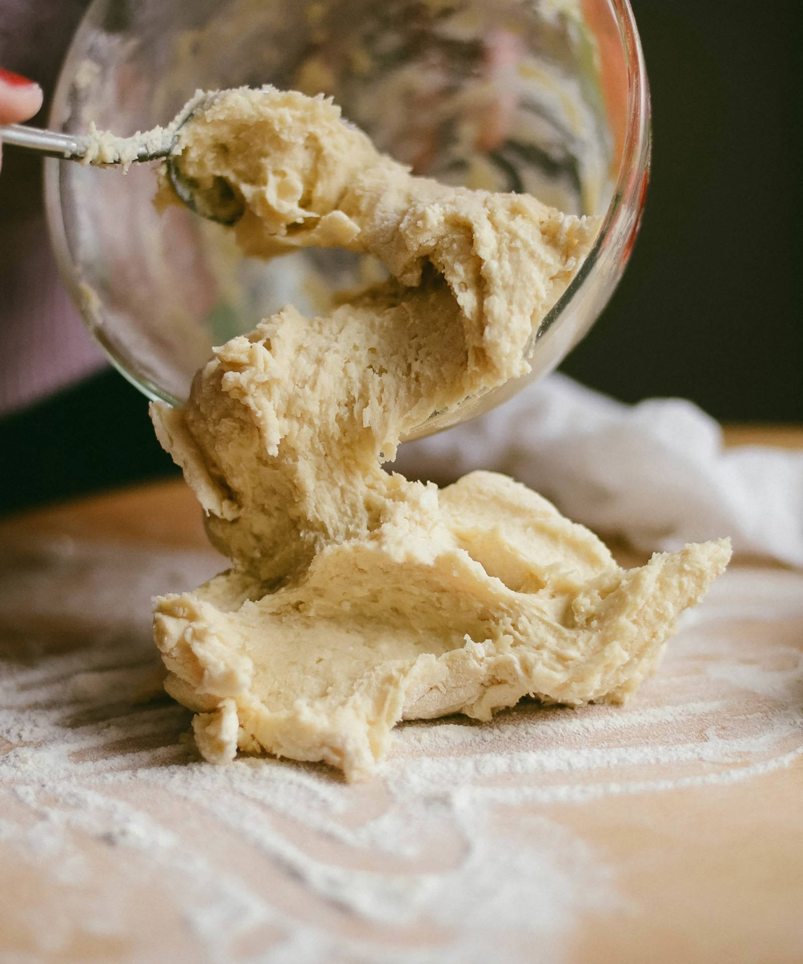 Teig aus Schüssel auf bemehltes Holzbrett.