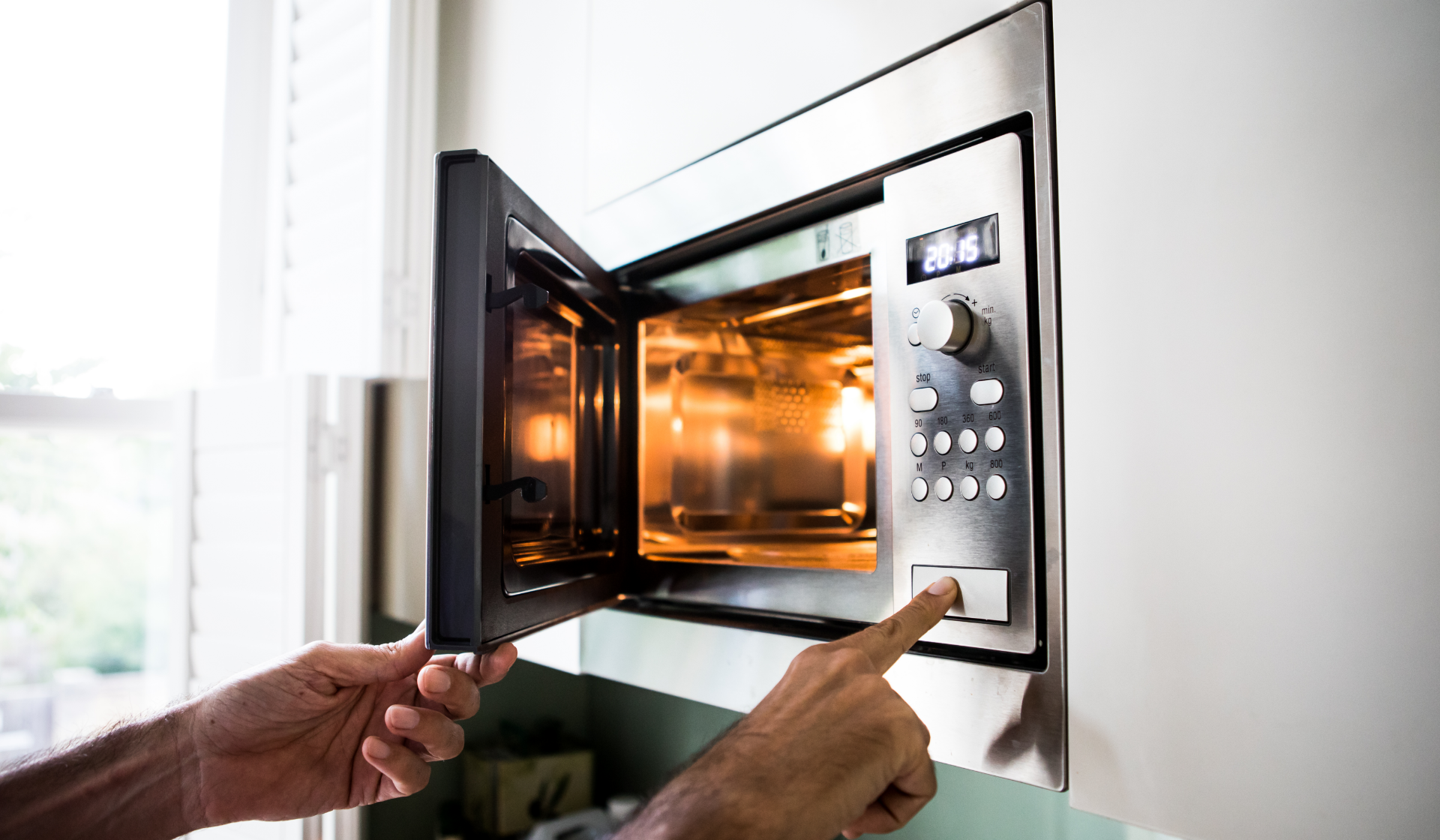 Ein Mann stellt eine Mikrowelle ein.