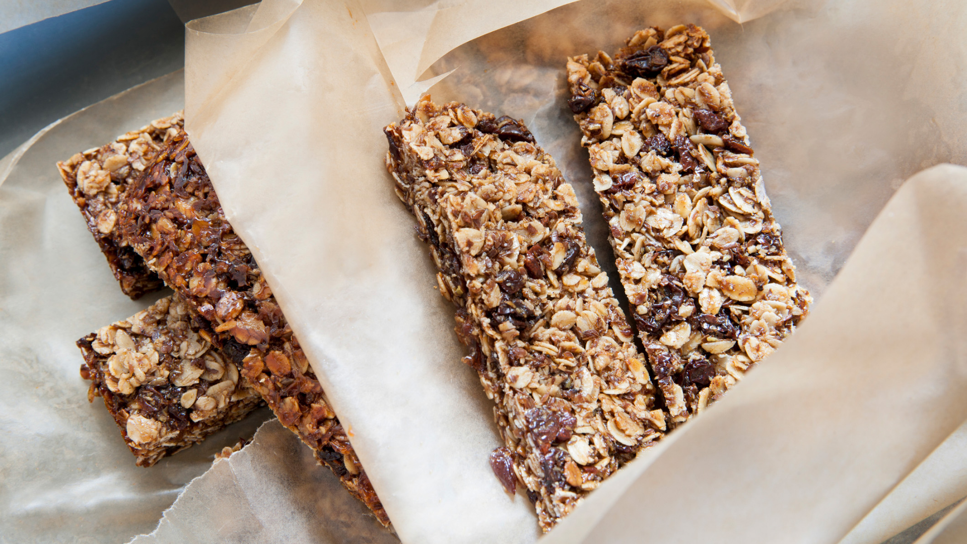 Müsli-Riegel mit Haferflocken und Trockenfrüchten auf Backpapier.
