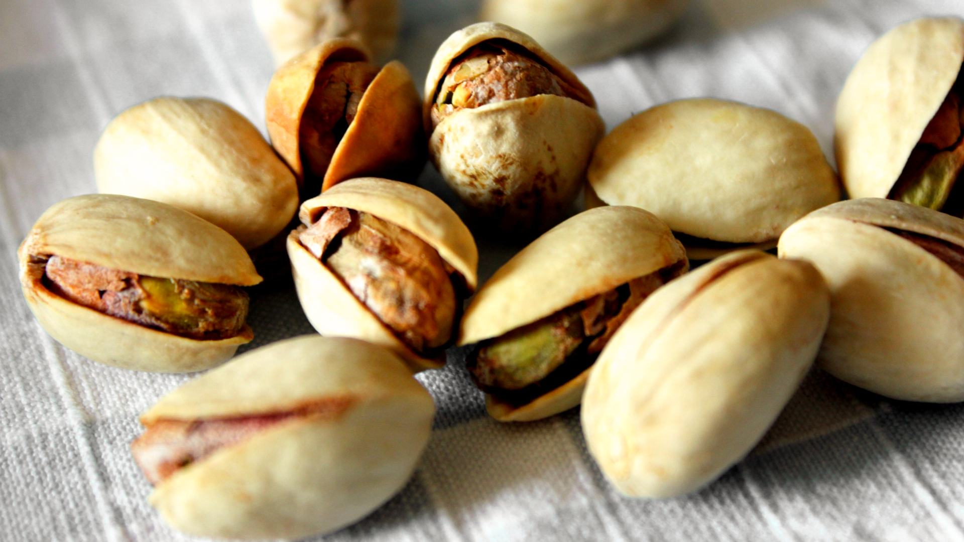 Nahaufnahme von Pistazien auf weißem Tuch.