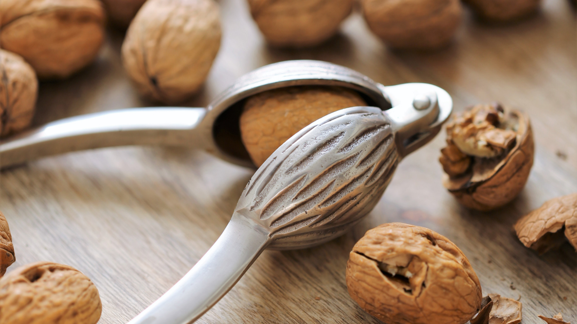 Walnüsse mit Nussknacker auf Holzbrett.