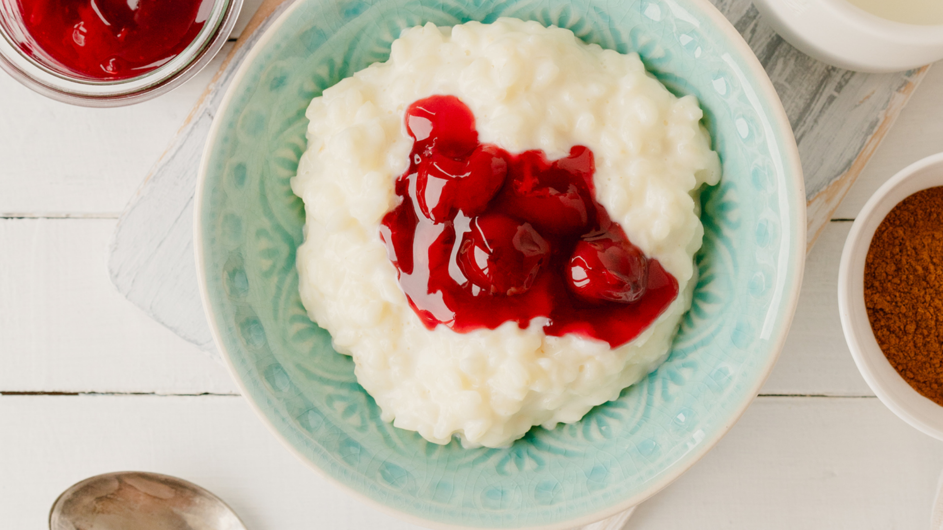 Milchreis mit Kirschen in blauer Schale.