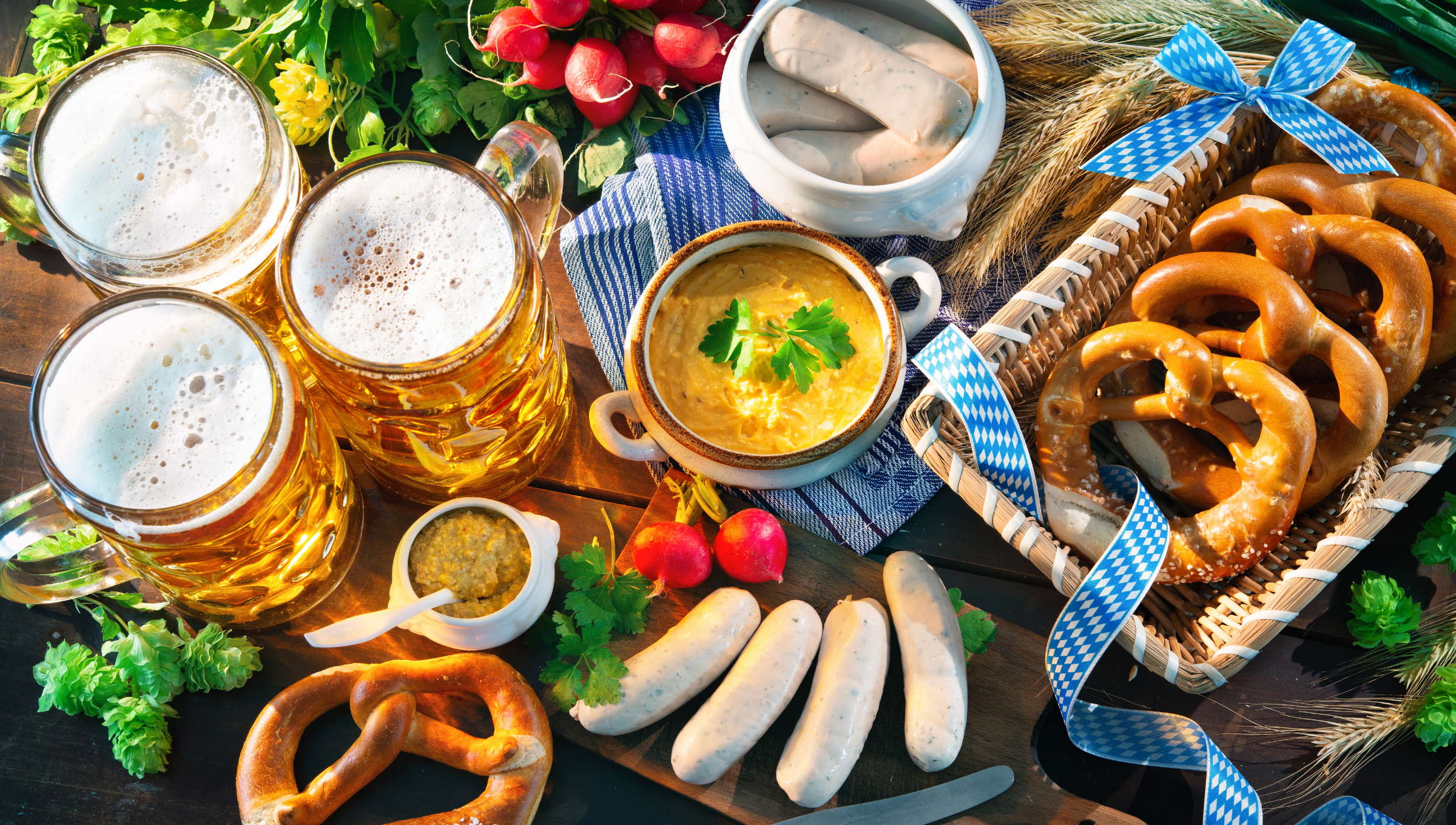 Ein traditionelles bayerisches Festessen mit Bier, Brezeln und Weißwurst.