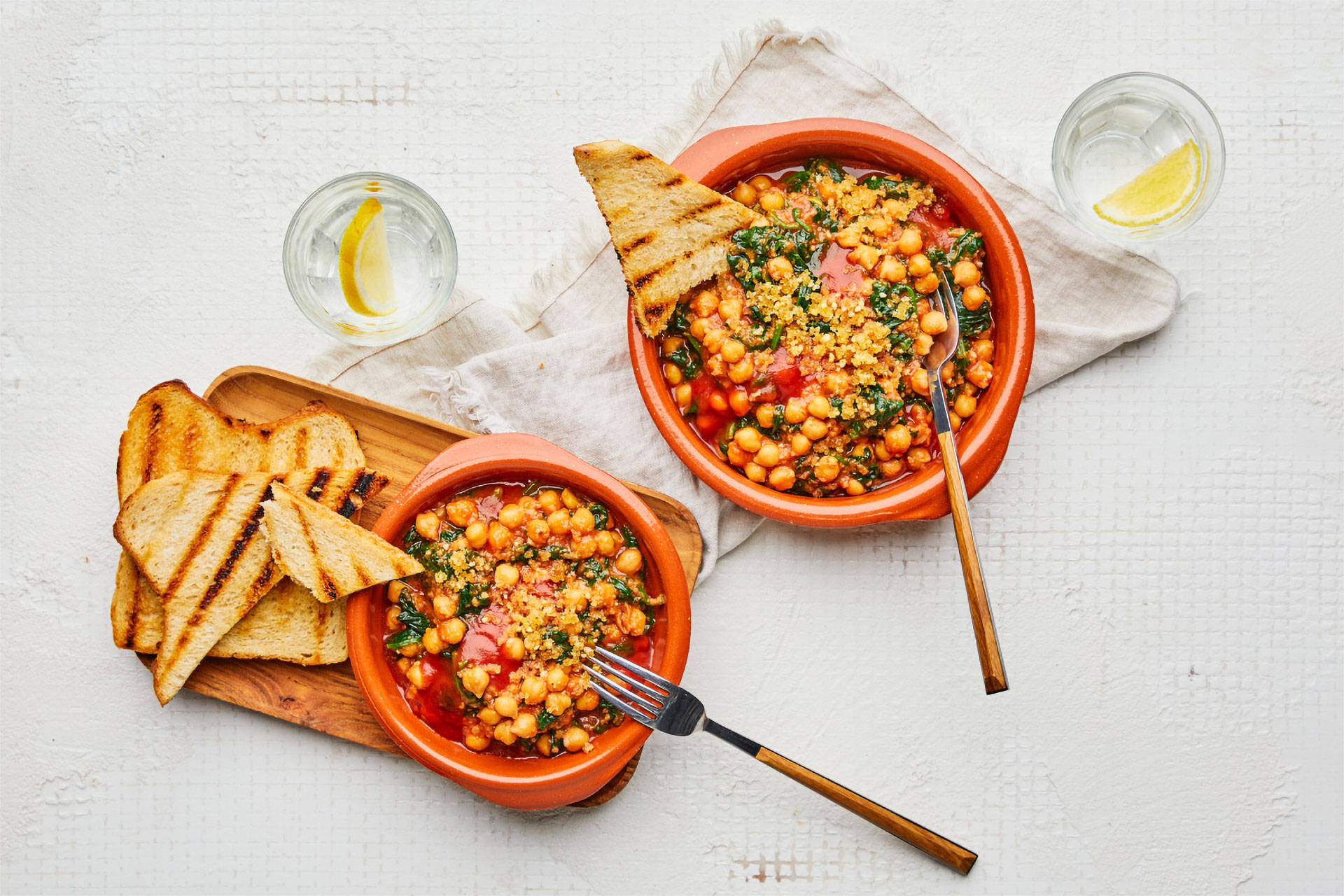 Veganes Chili mit Brot auf weißem Tisch.