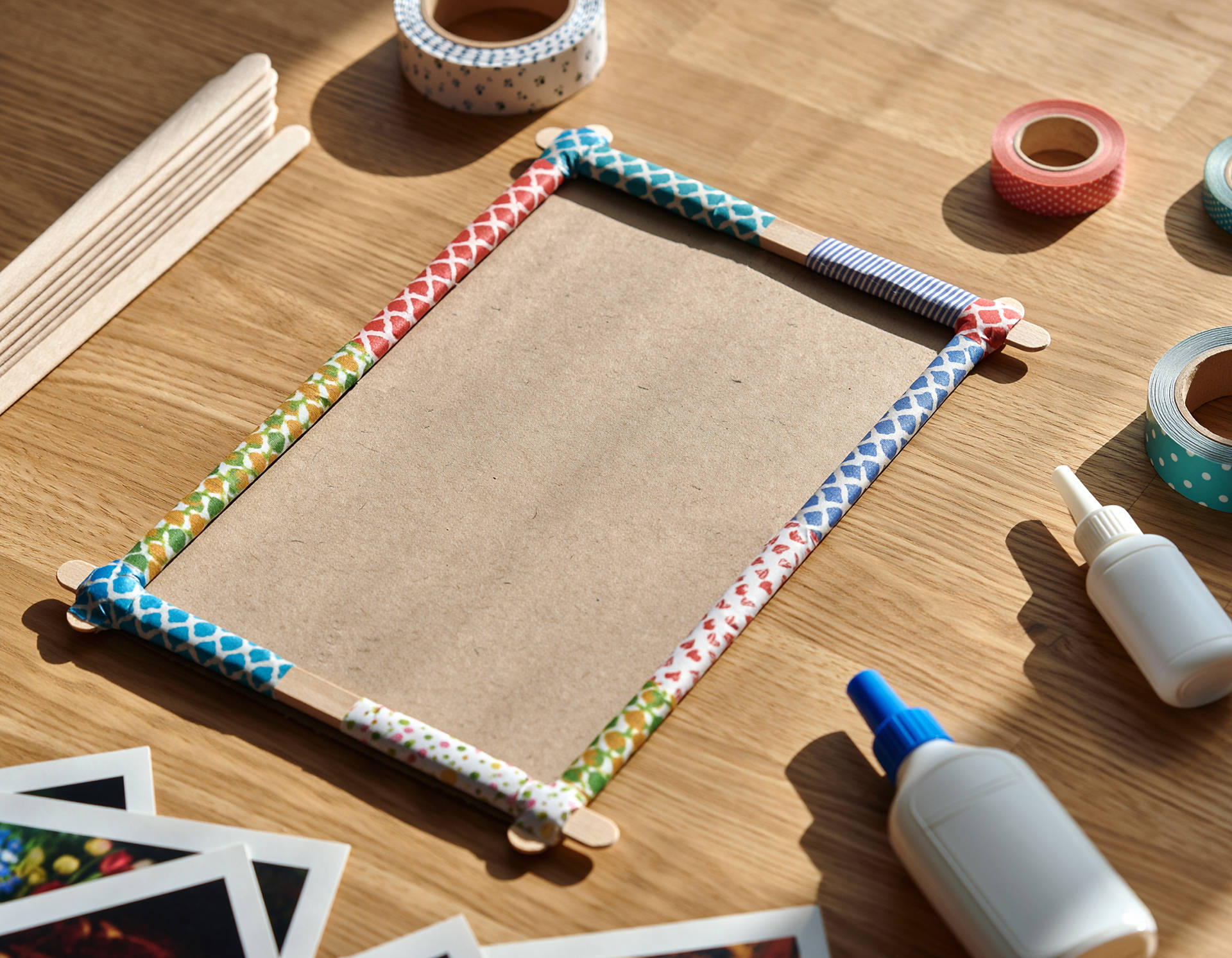 Auf einem Tisch liegt ein mit Tape selbst gebastelter Bilderrahmen. 