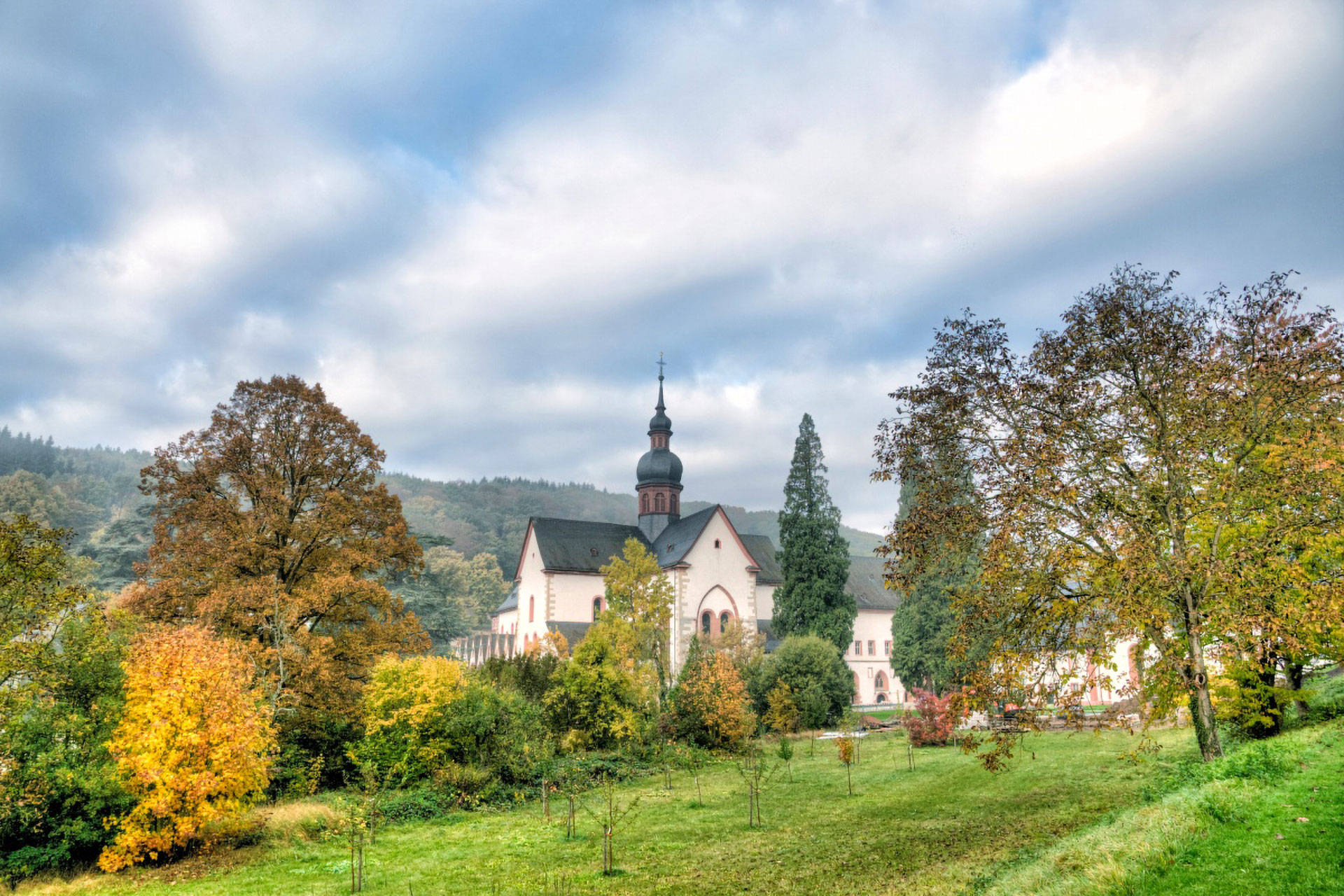 Zisterzienser Kloster Eberbach mit Garten und Bäumen im Herbst.