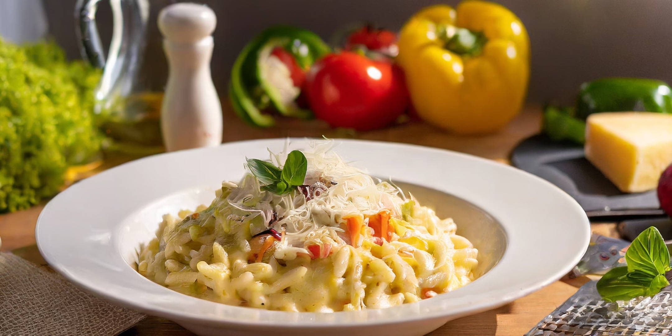 Cremige Risoni-Nudeln mit Käse, Basilikum und Gemüse.