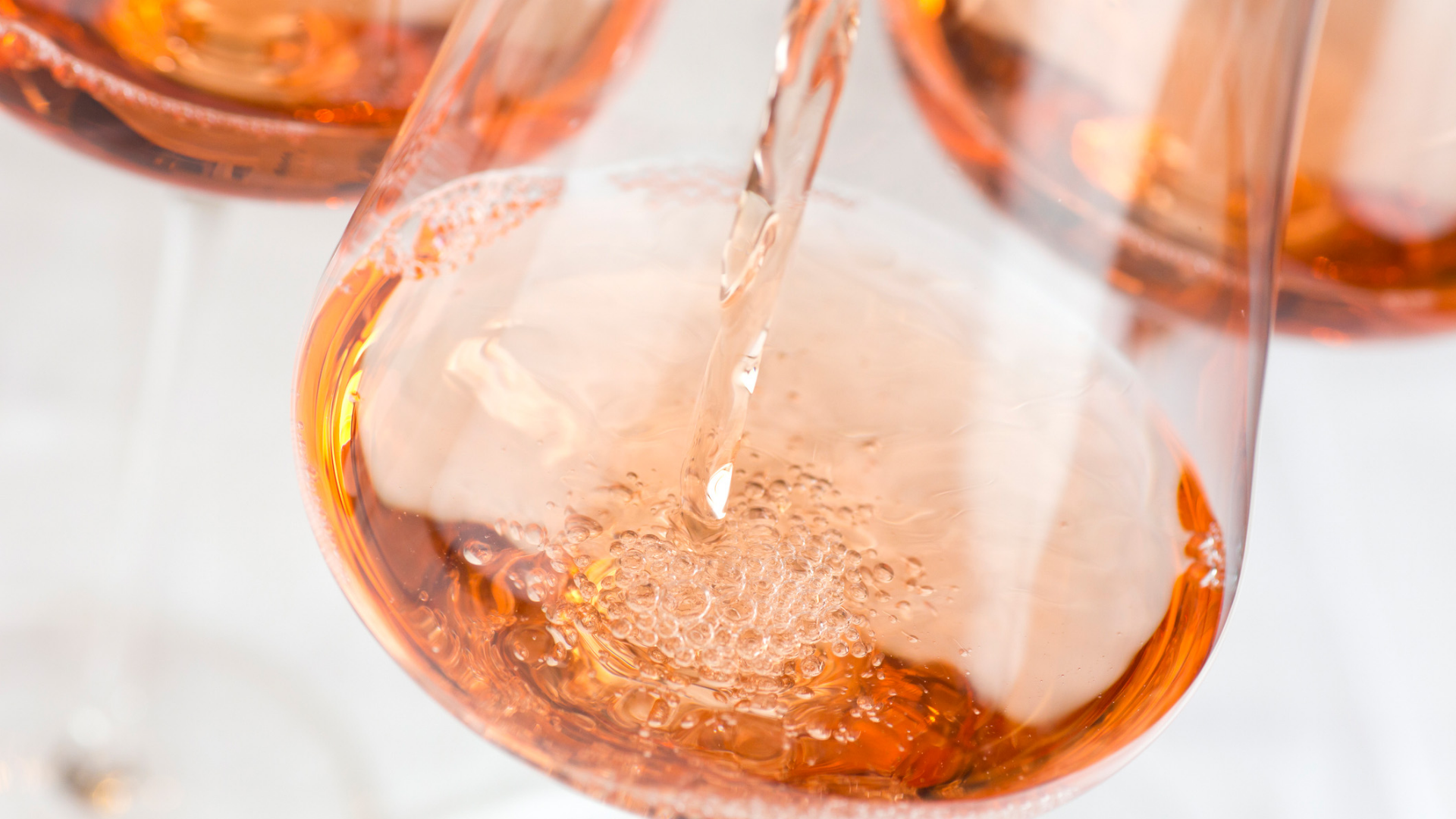 Einschenken von Roséwein in ein Glas, Bläschenbildung.