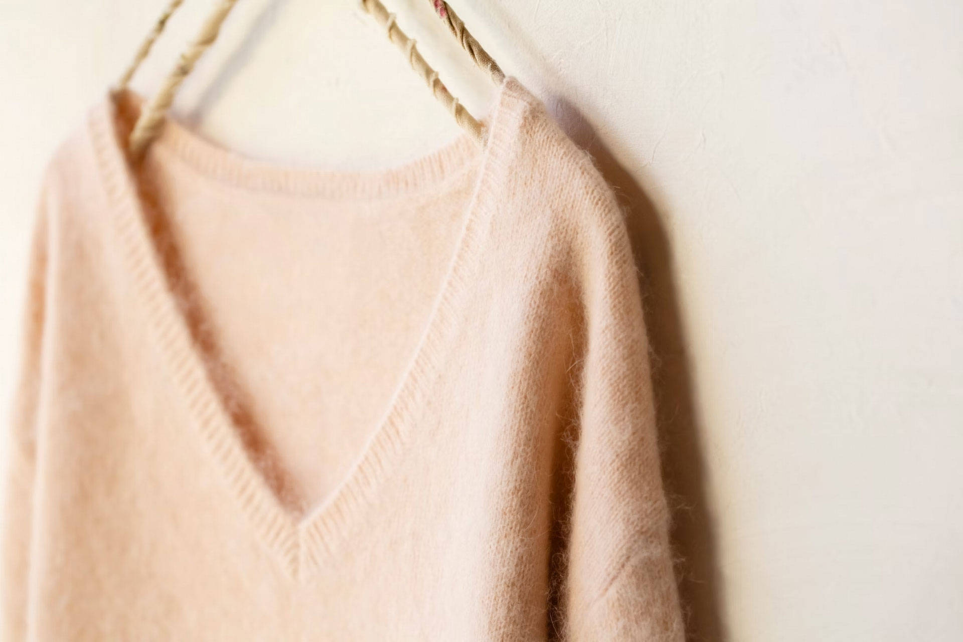 Ein Pullover aus Kaschmir hängt an einem Kleiderbügel.