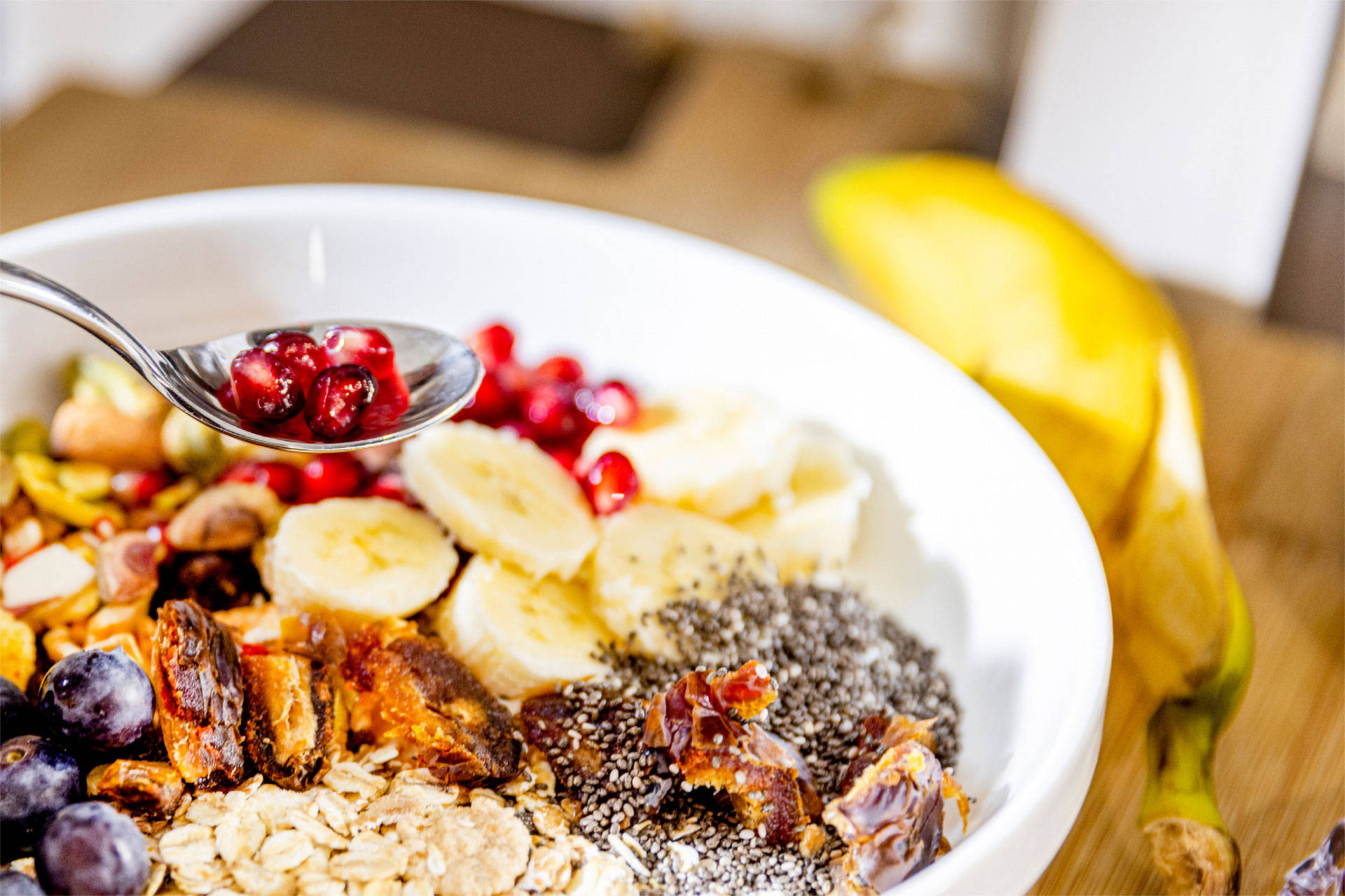 Müsli Bowl mit Chia-Samen, Hafer, Blaubeeren, Banane, Granatapfel, Datteln und Blaubeeren