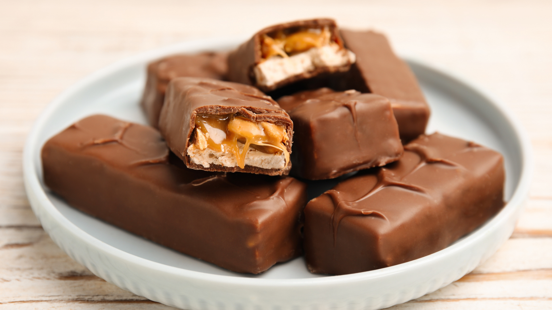 Schokoladenriegel mit Karamell und Nüssen auf einem Teller.