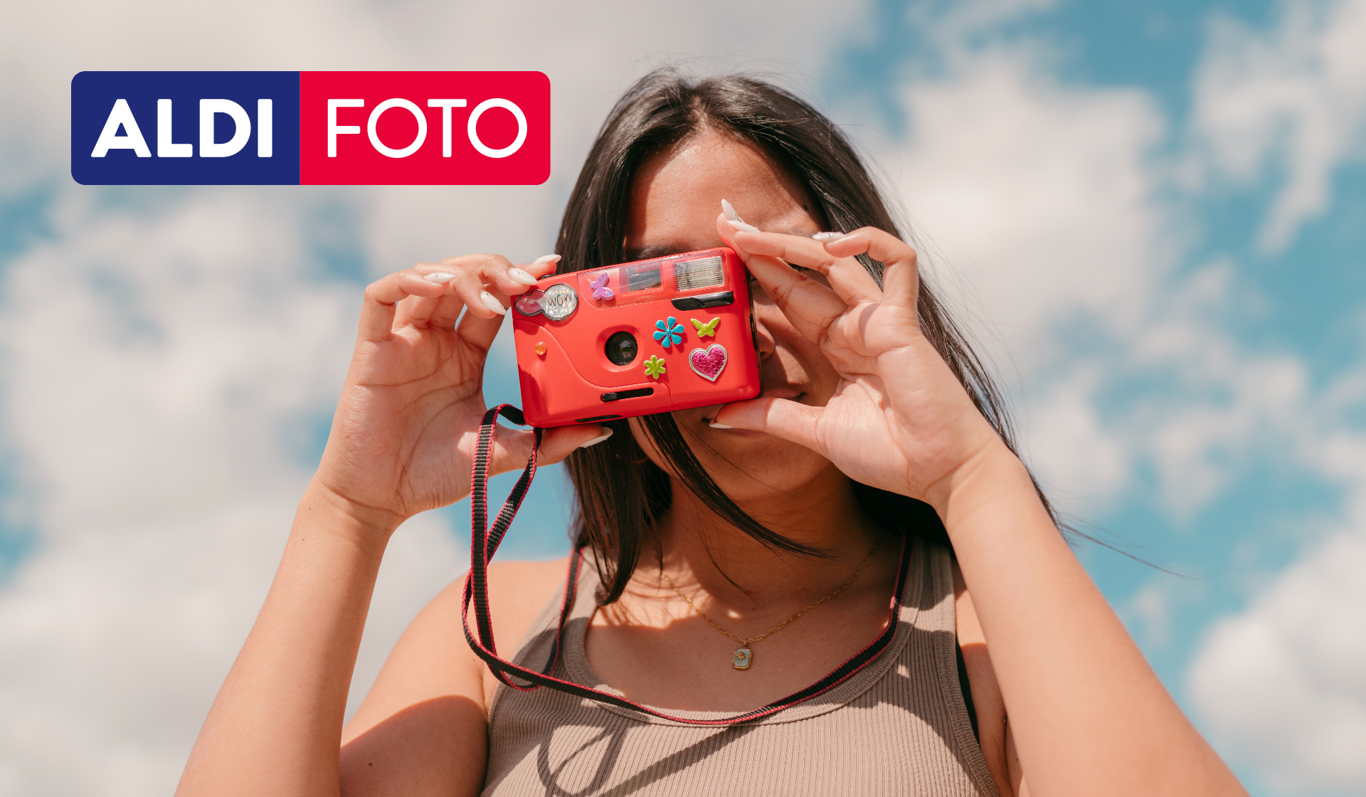 Ein junge Frau macht ein Foto mit ihrer Analogkamera.