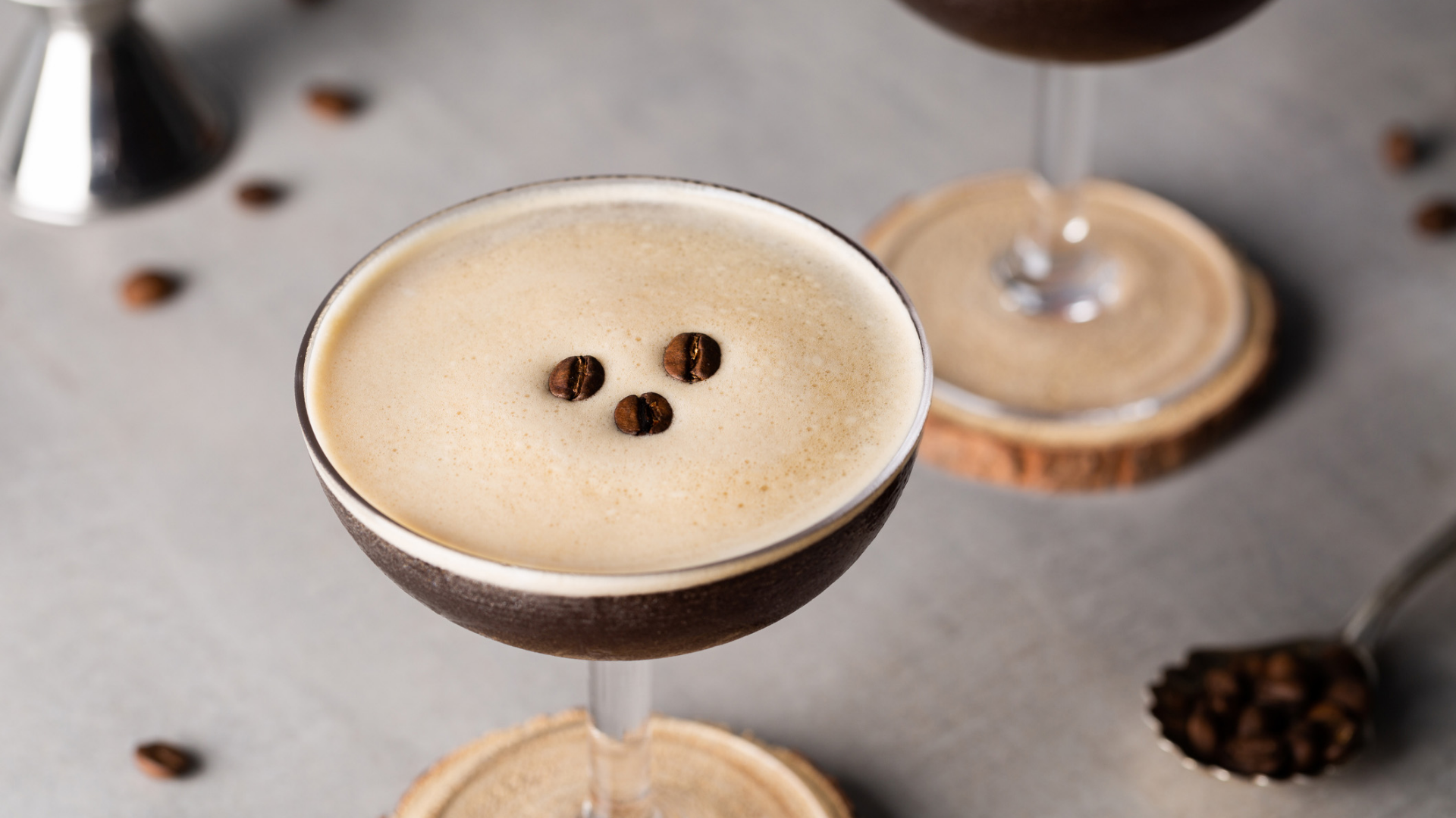 Dunkler Cocktail mit hellem Schaum und Kaffeebohnen.