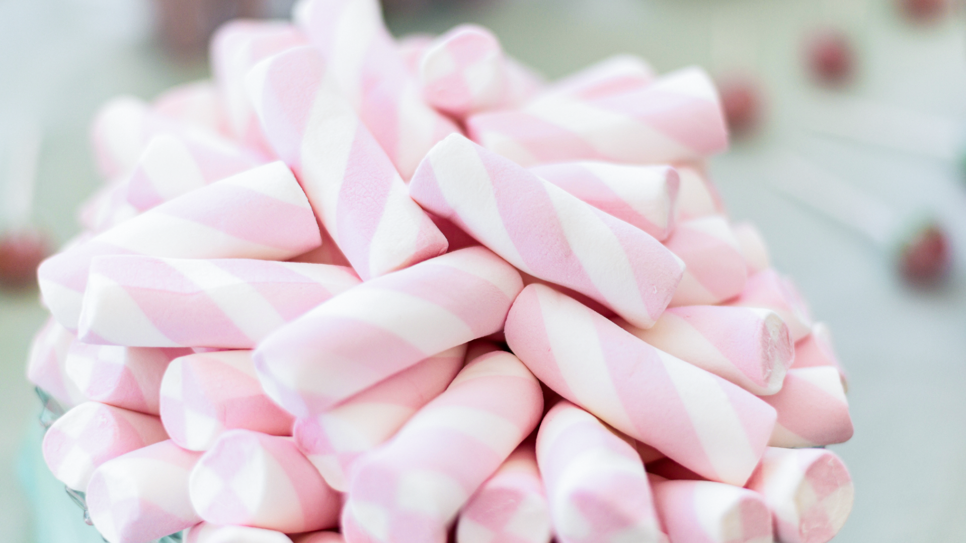 Rosa-weiß gestreifte Marshmallows, Süßigkeiten, Detailaufnahme, heller Hintergrund.