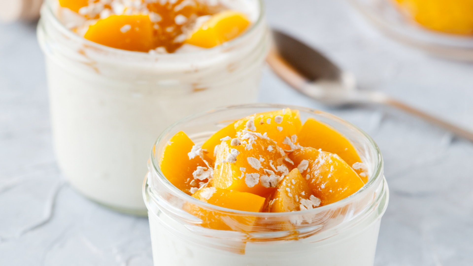 Joghurt mit Pfirsichstückchen und Haferflocken im Glas.