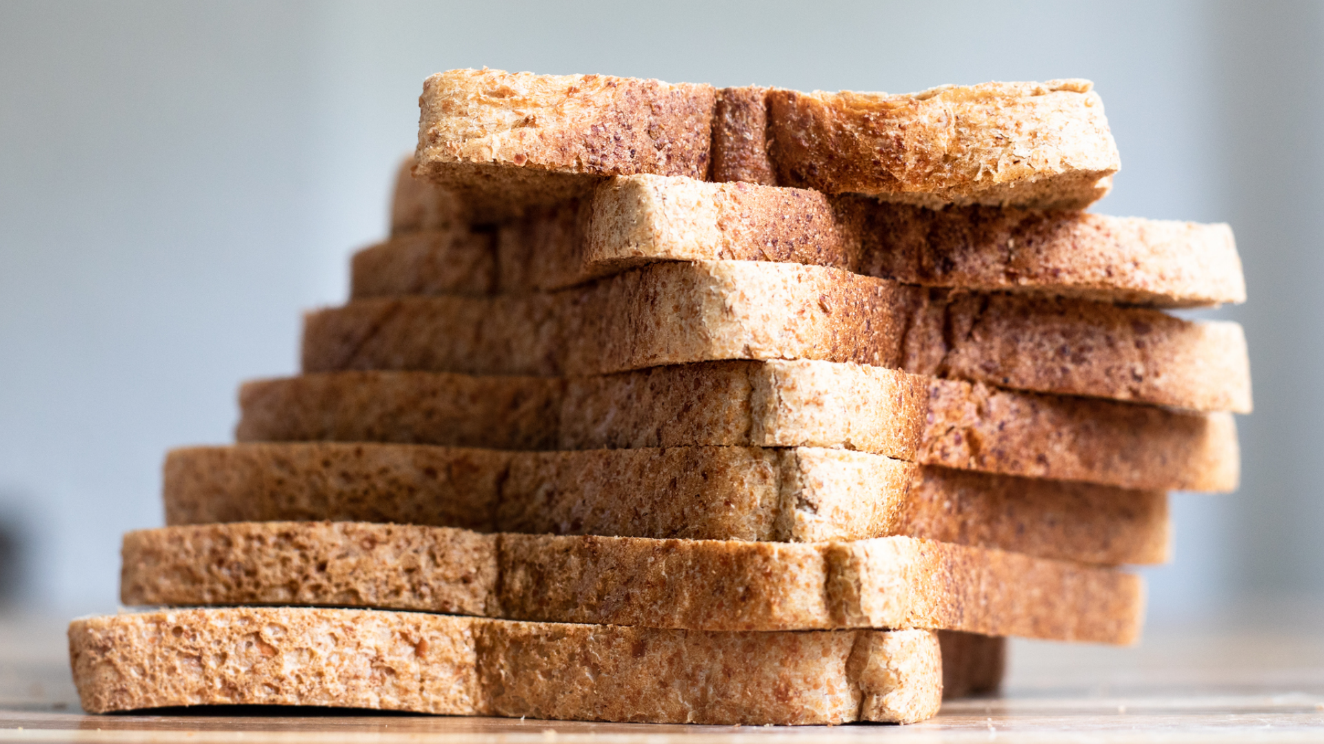 Stapel brauner Toastbrotscheiben vor unscharfem Hintergrund.