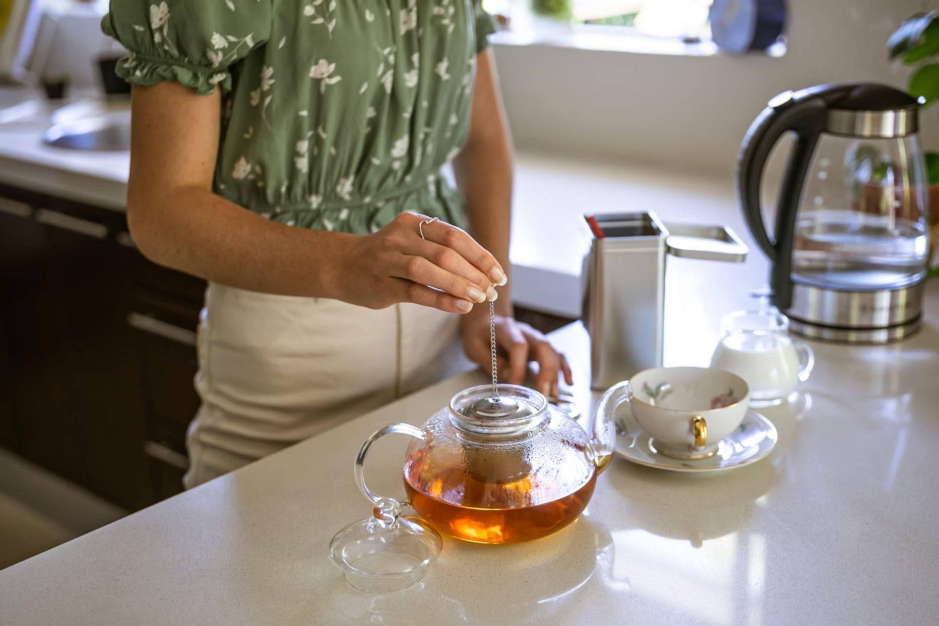 Eine Frau bereitet sich gerade einen frischen Tee zu.