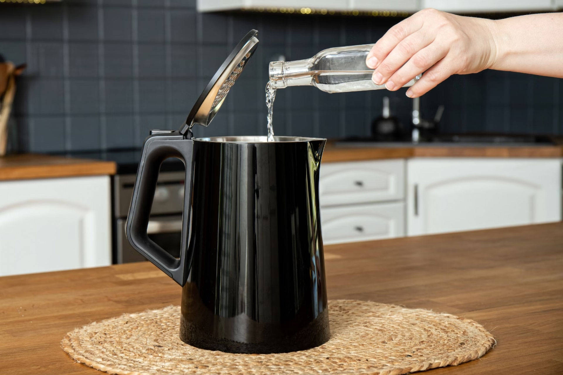 Eine Person füllt Essig in einen Wasserkocher.