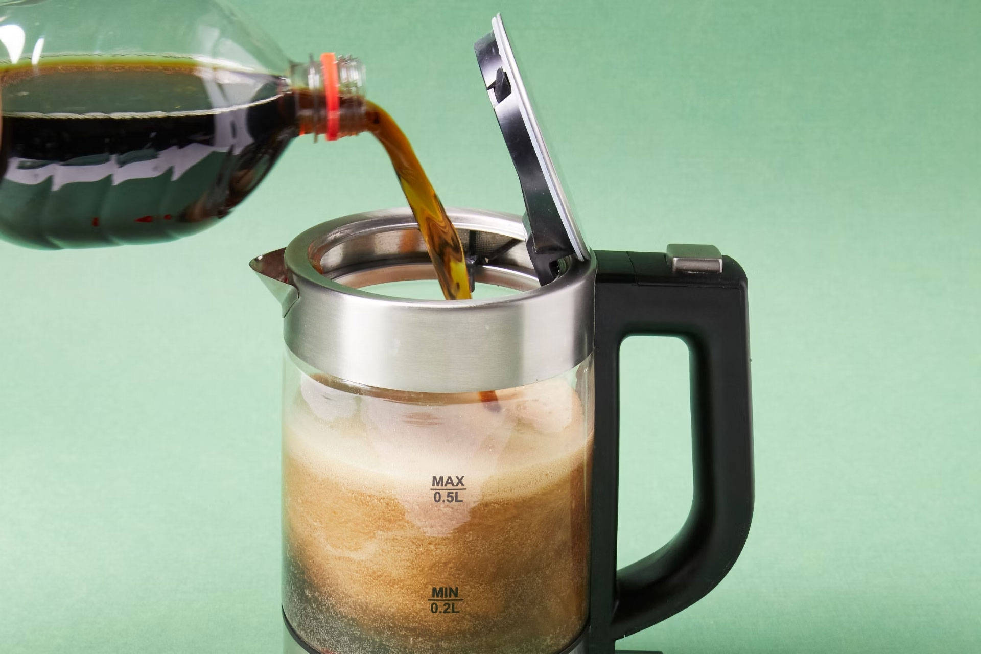 Ein Wasserkocher wird gerade mit Cola befüllt.