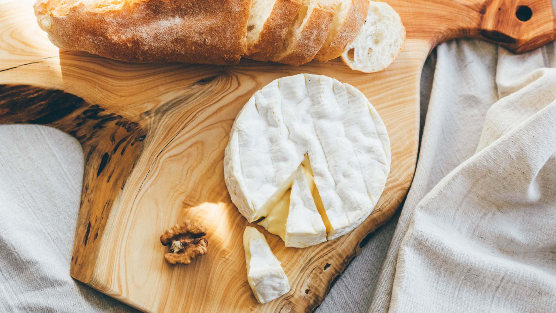Weichkäse mit Brot, Walnuss auf Holzbrett.