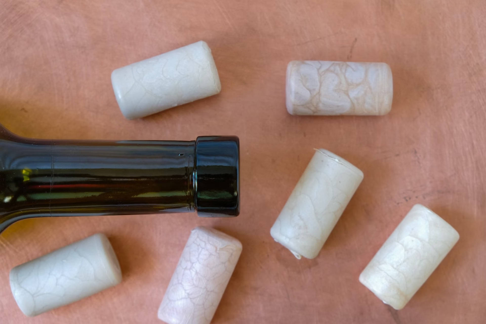 Kunststoffkorken neben einer Flasche Wein.