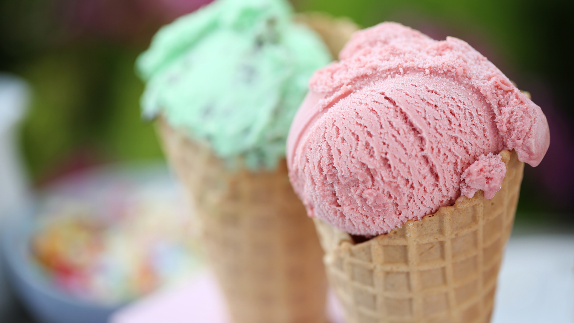 Zwei Eiswaffeln mit rosa und grünem Eis.